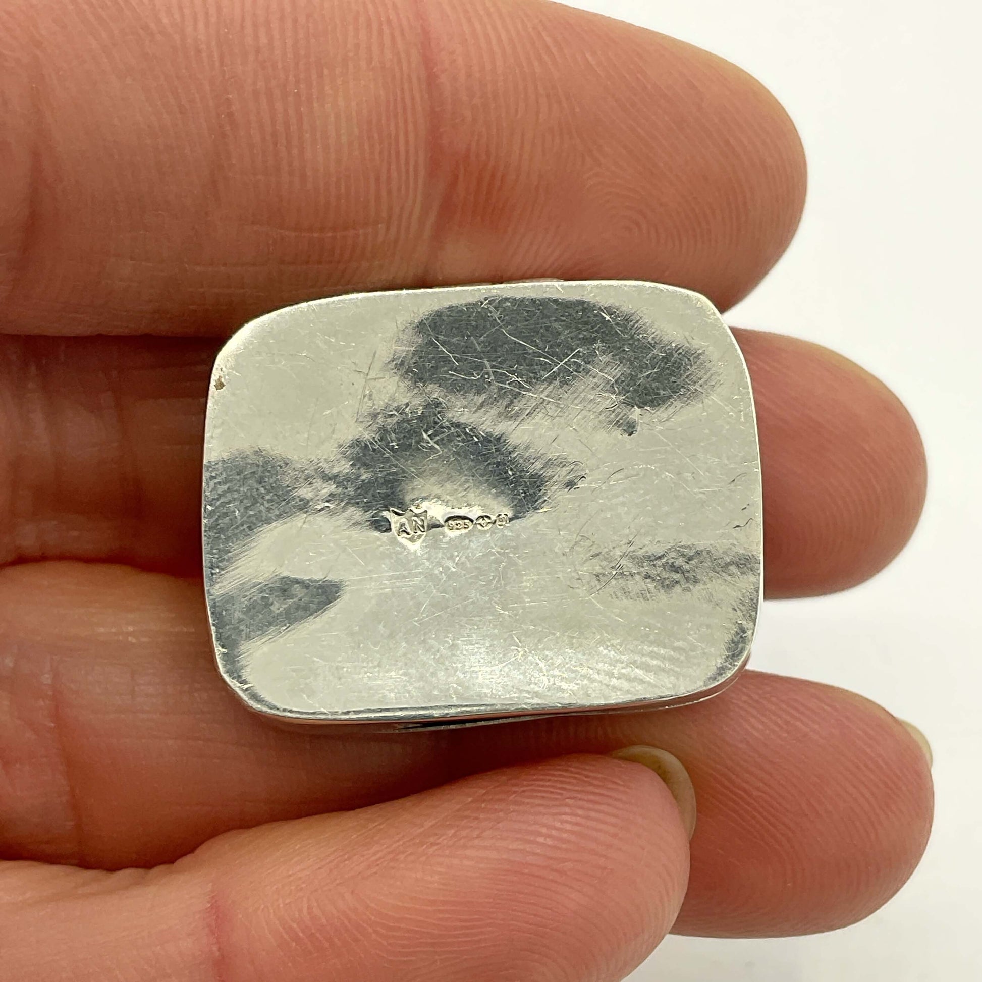 base of Vintage Black Gemstone Silver Pill Box with hallmarks in hand