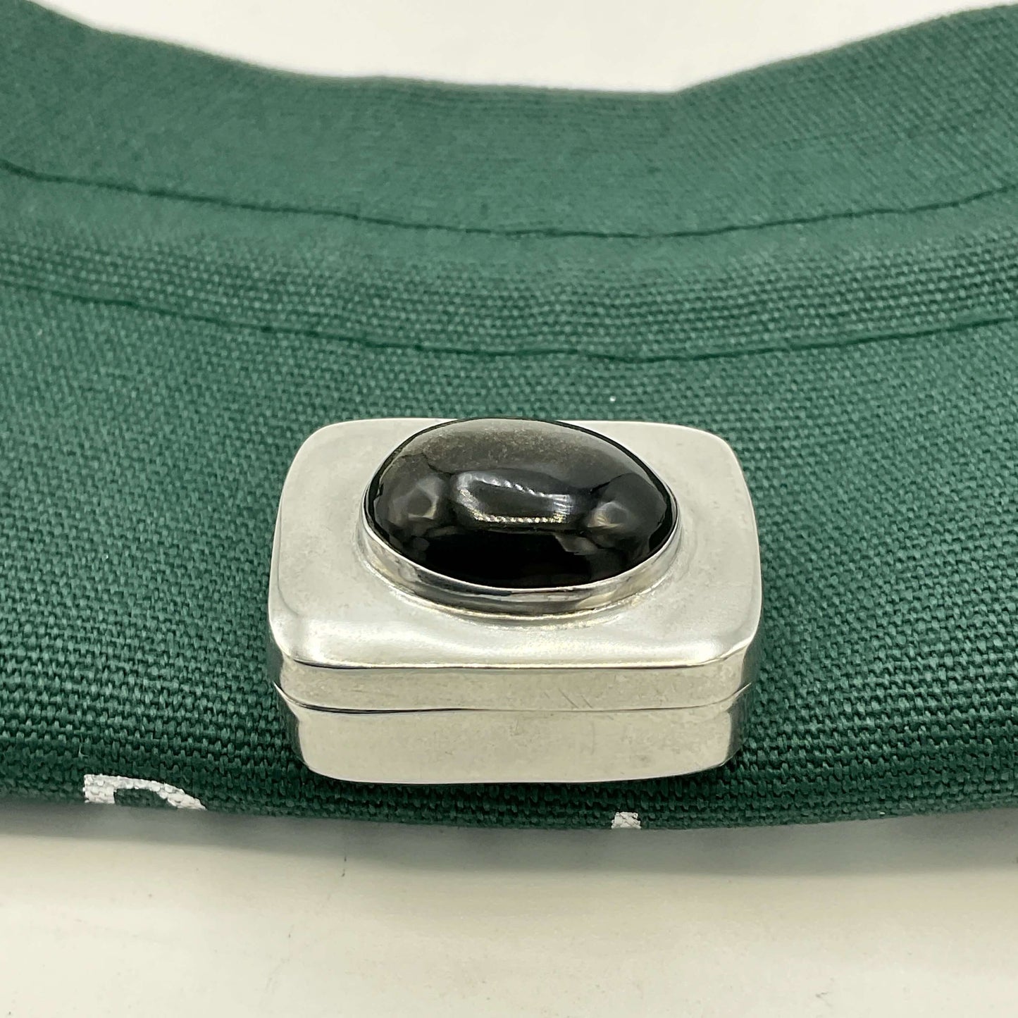 Vintage Black Gemstone Silver Pill Box on green bag