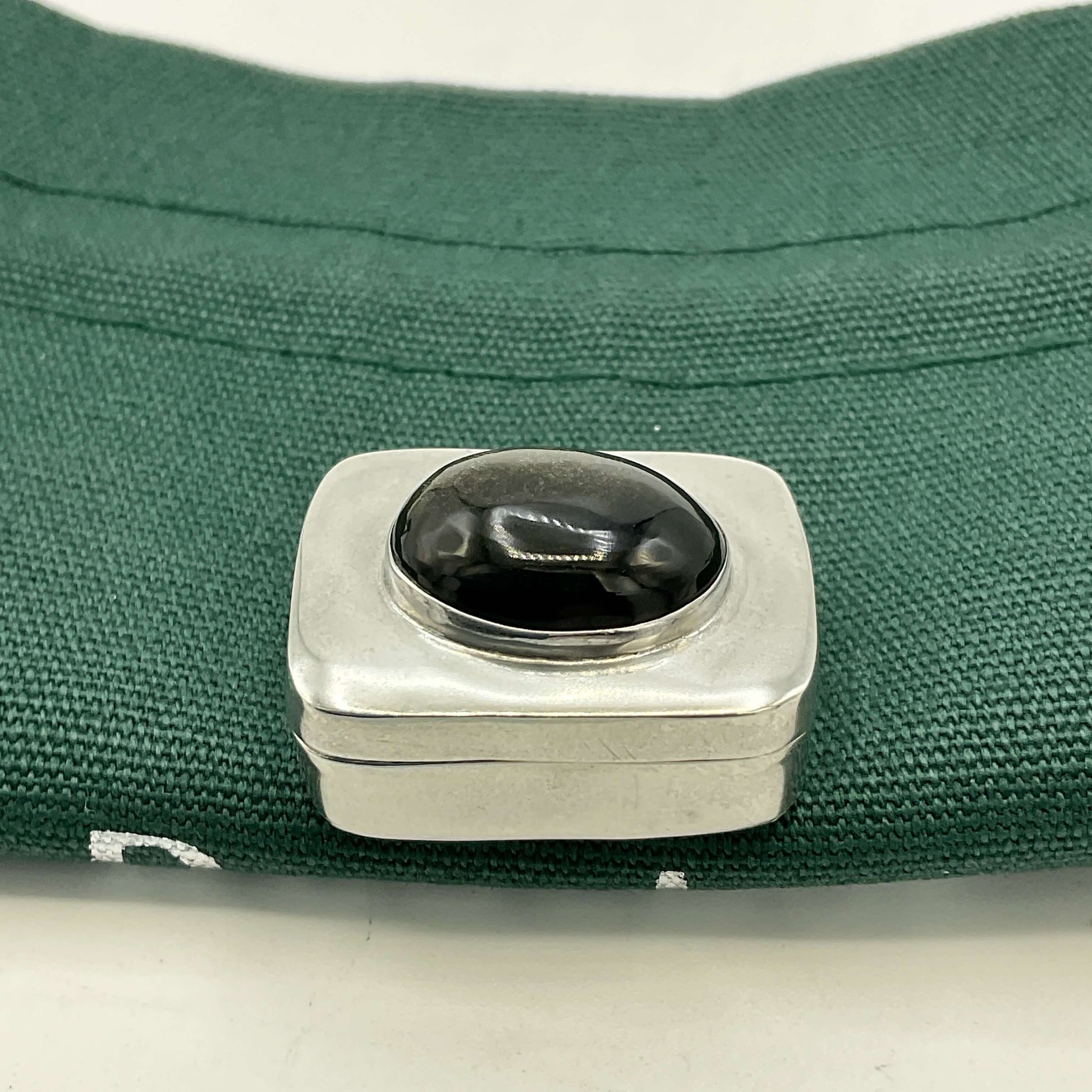 Vintage Black Gemstone Silver Pill Box on green bag