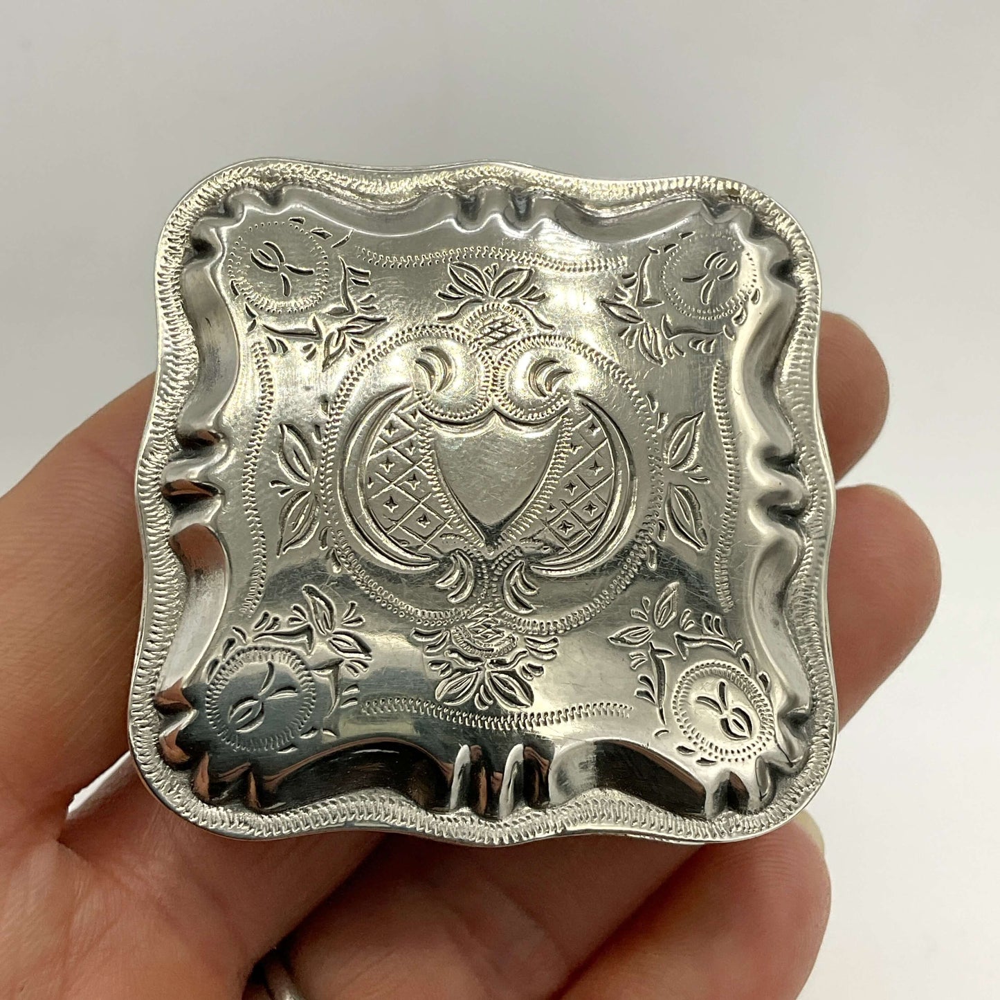 Vintage Small Dutch Silver Box Held in a hand with a white background 