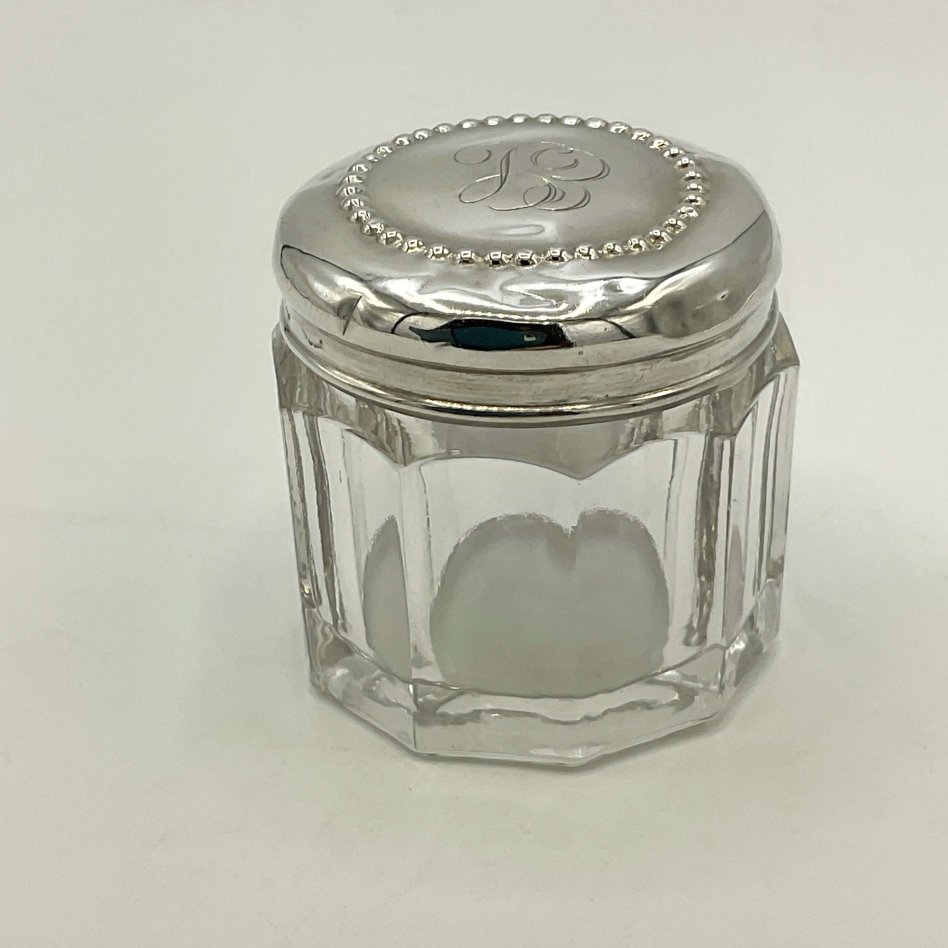 Clear glass jar with a silver lid on a white background