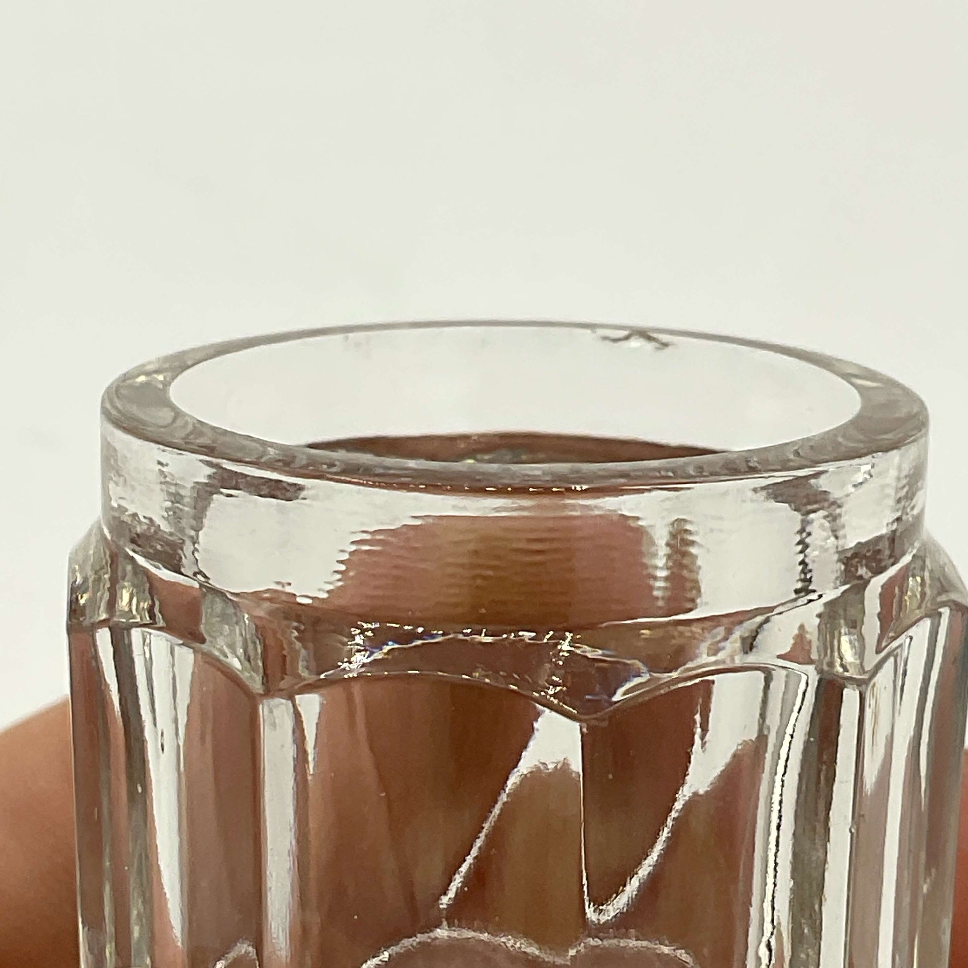 Clear glass jar with a hexagonal shape on a white background