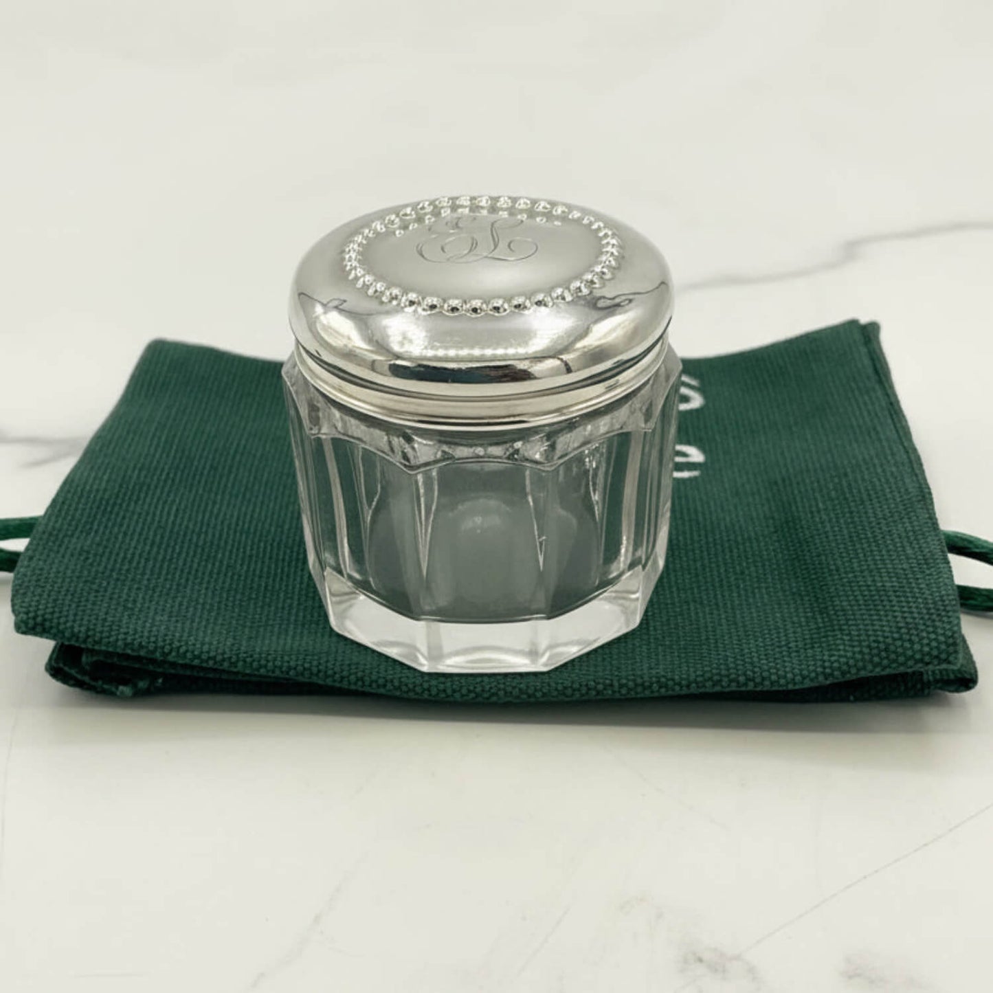 Glass jar with silver lid on a green cloth