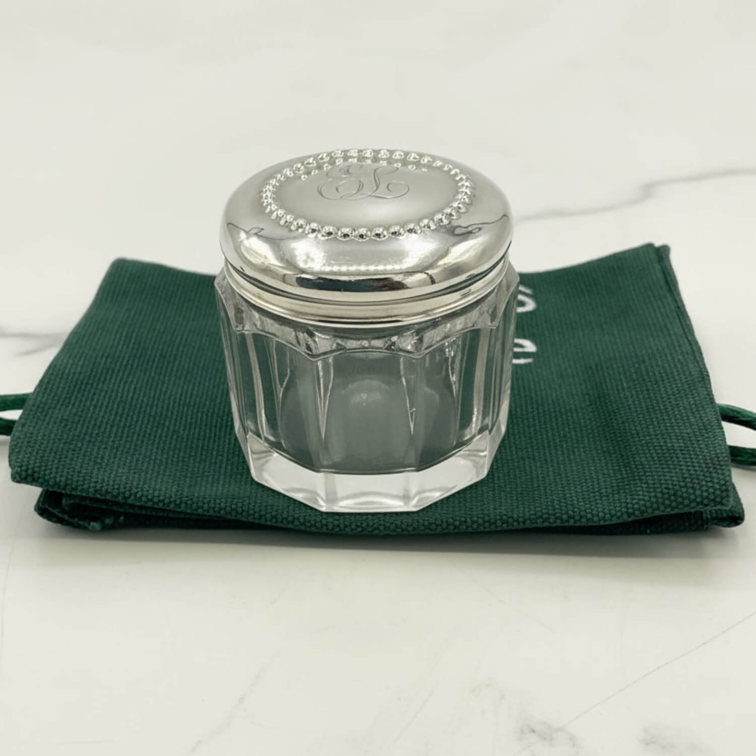 Glass jar with silver lid on a green cloth
