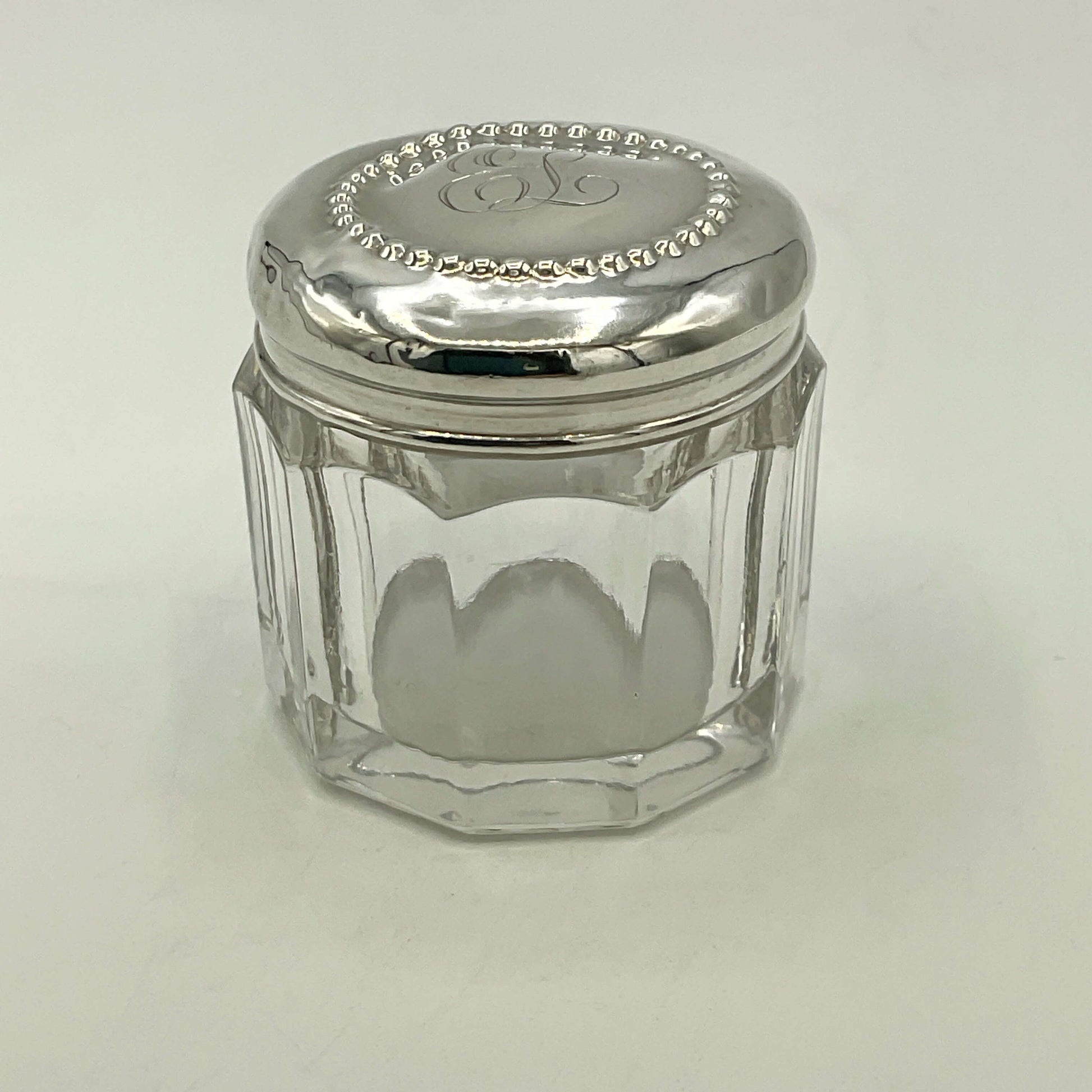 Clear glass jar with a silver lid on a white background