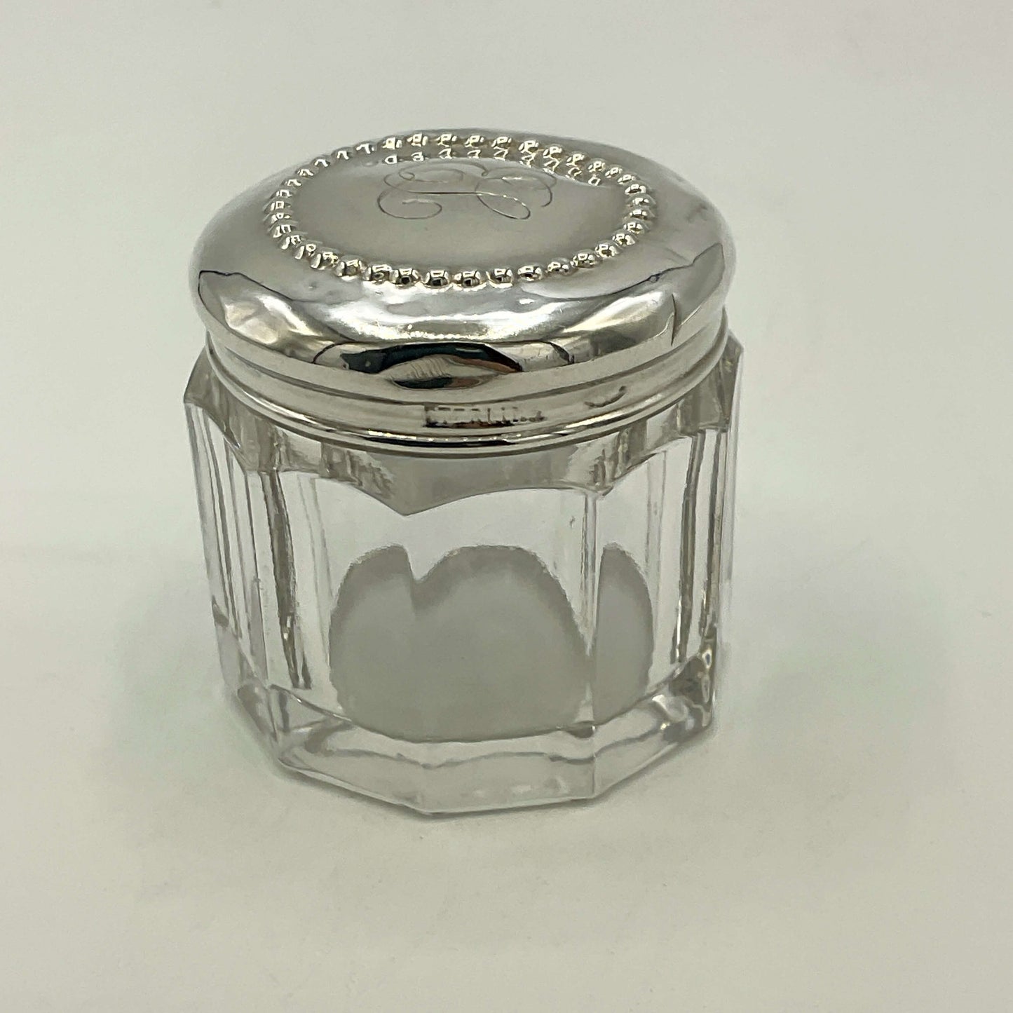 Clear glass jar with a silver lid on a white background