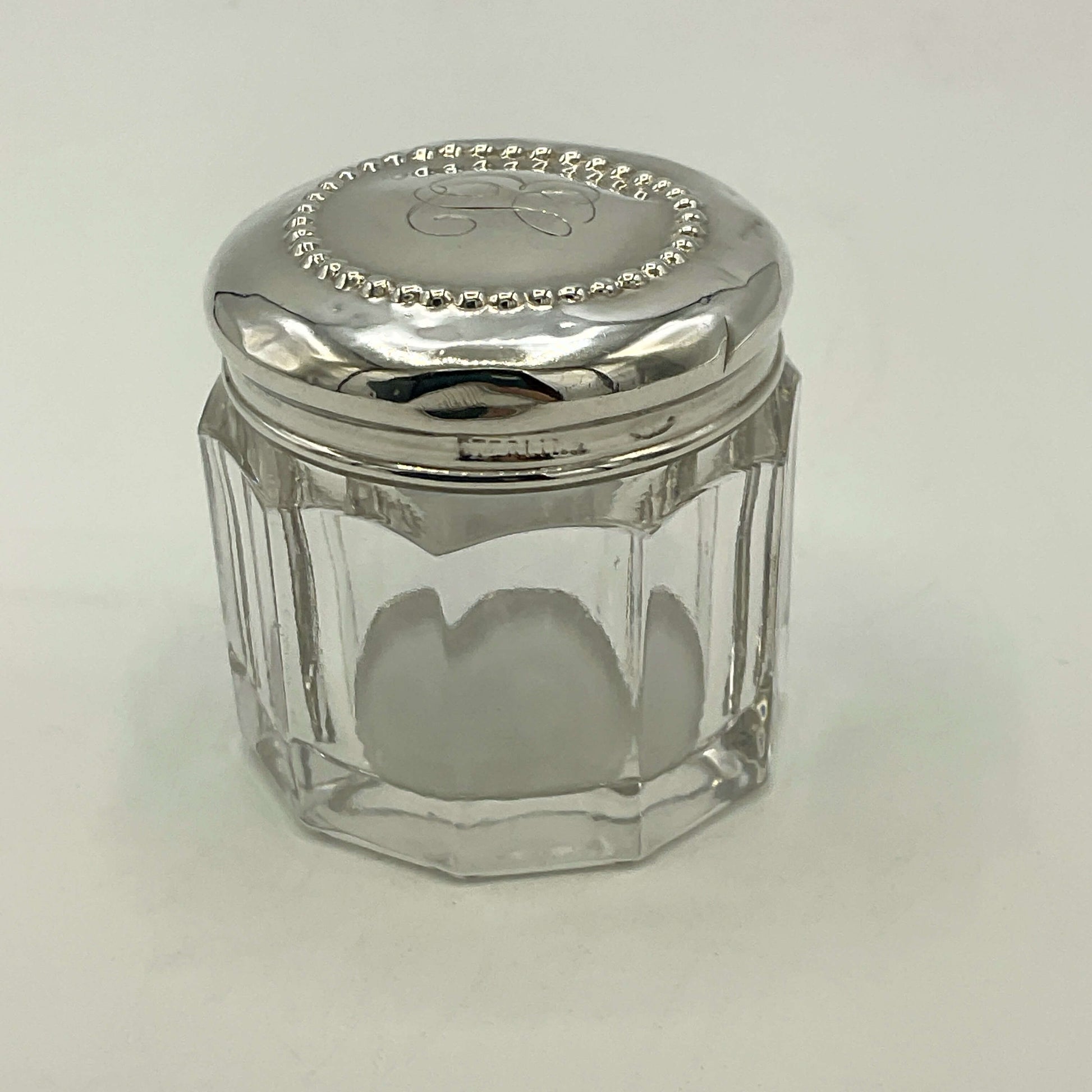 Clear glass jar with a silver lid on a white background