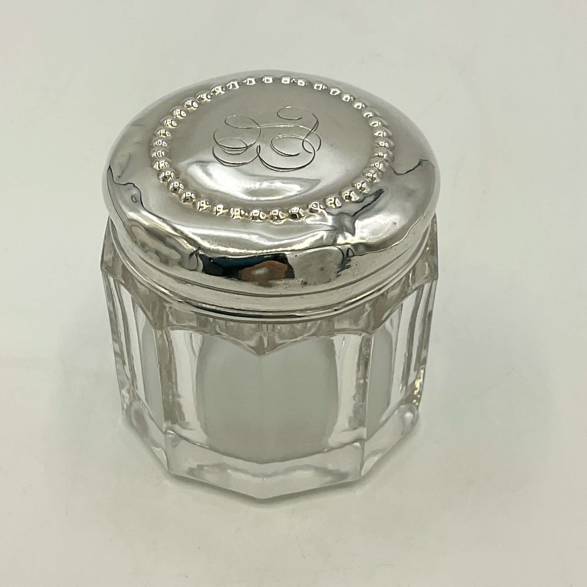 Clear glass jar with a silver lid on a white background