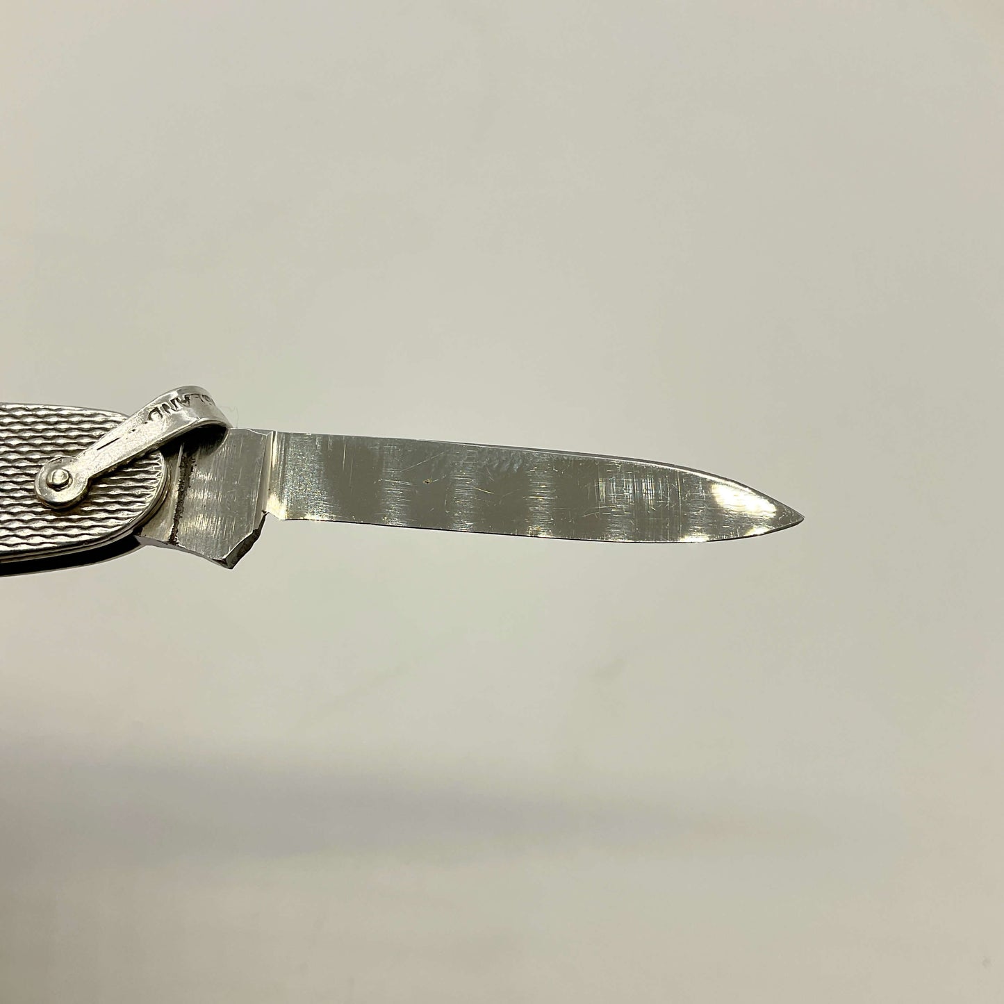 Folding knife with a steel blade on a light gray background
