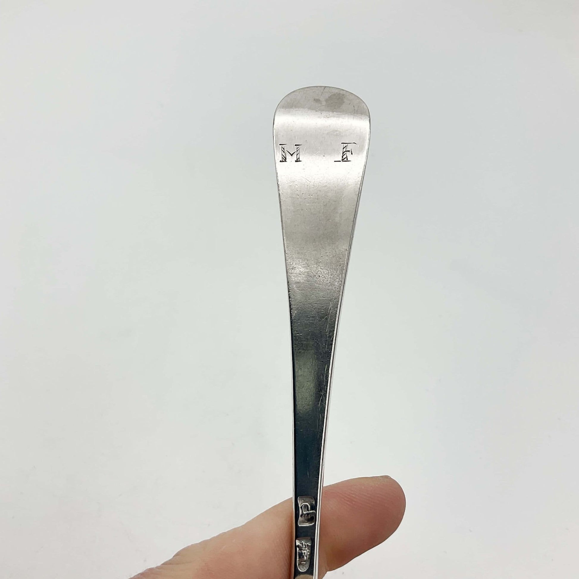 MF engraved at the top of a handle of silver spoon