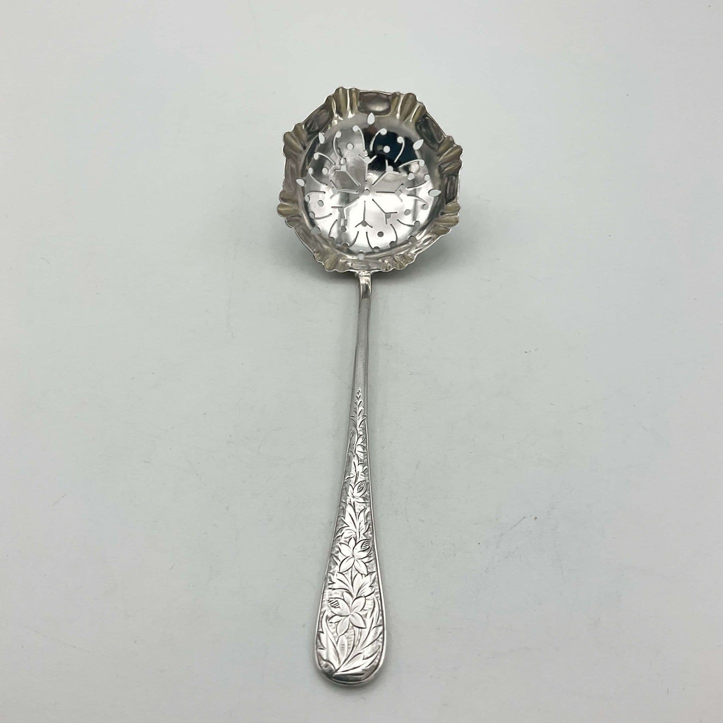 Decorative silver sugar sifter on a wooden surface
