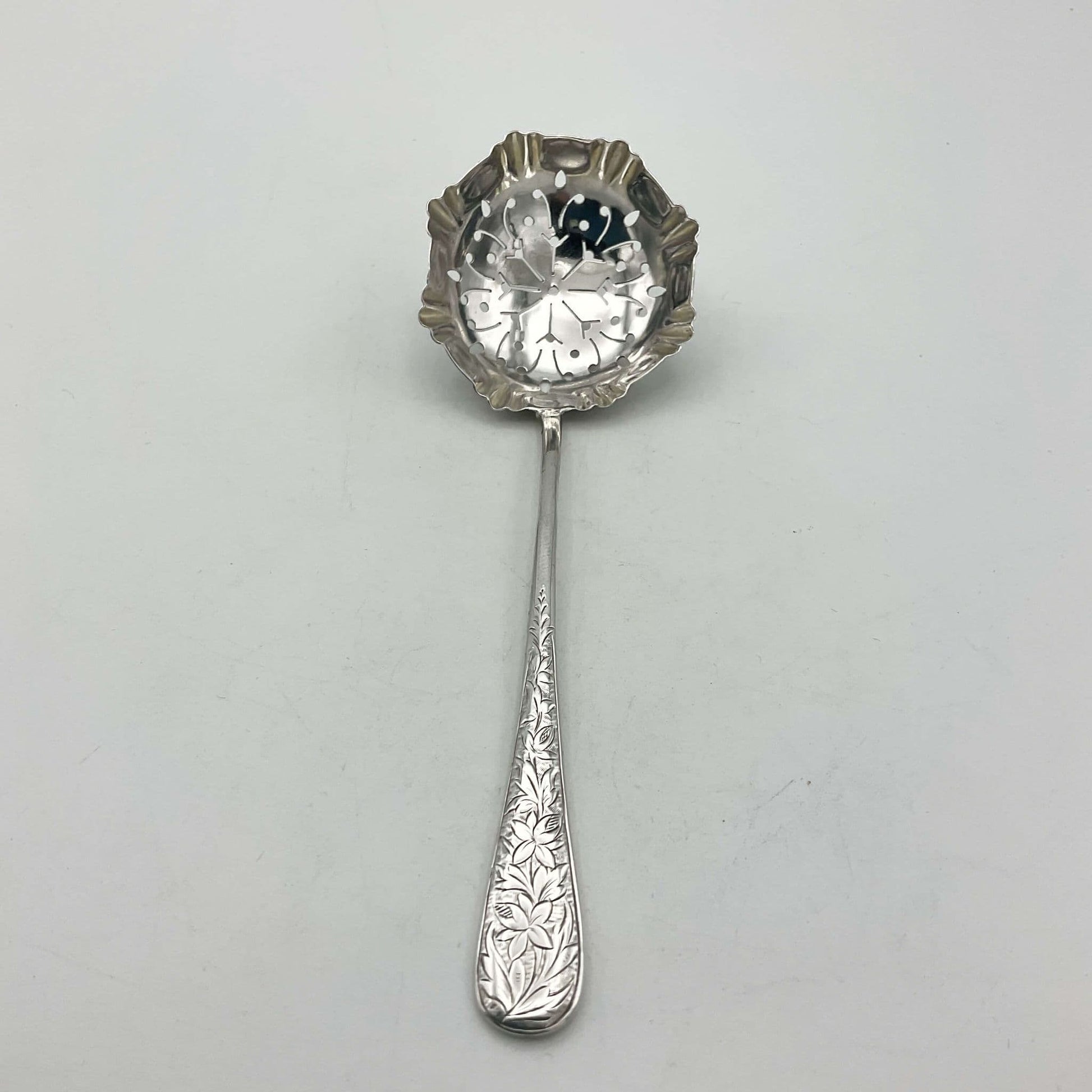 Decorative silver sugar sifter on a wooden surface