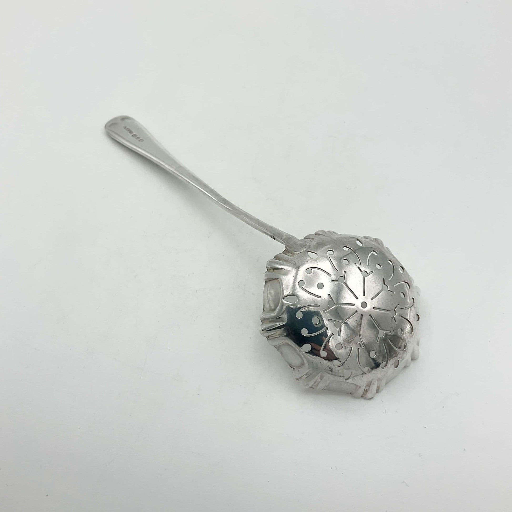 Silver decorative sugar sifter spoon on a white background
