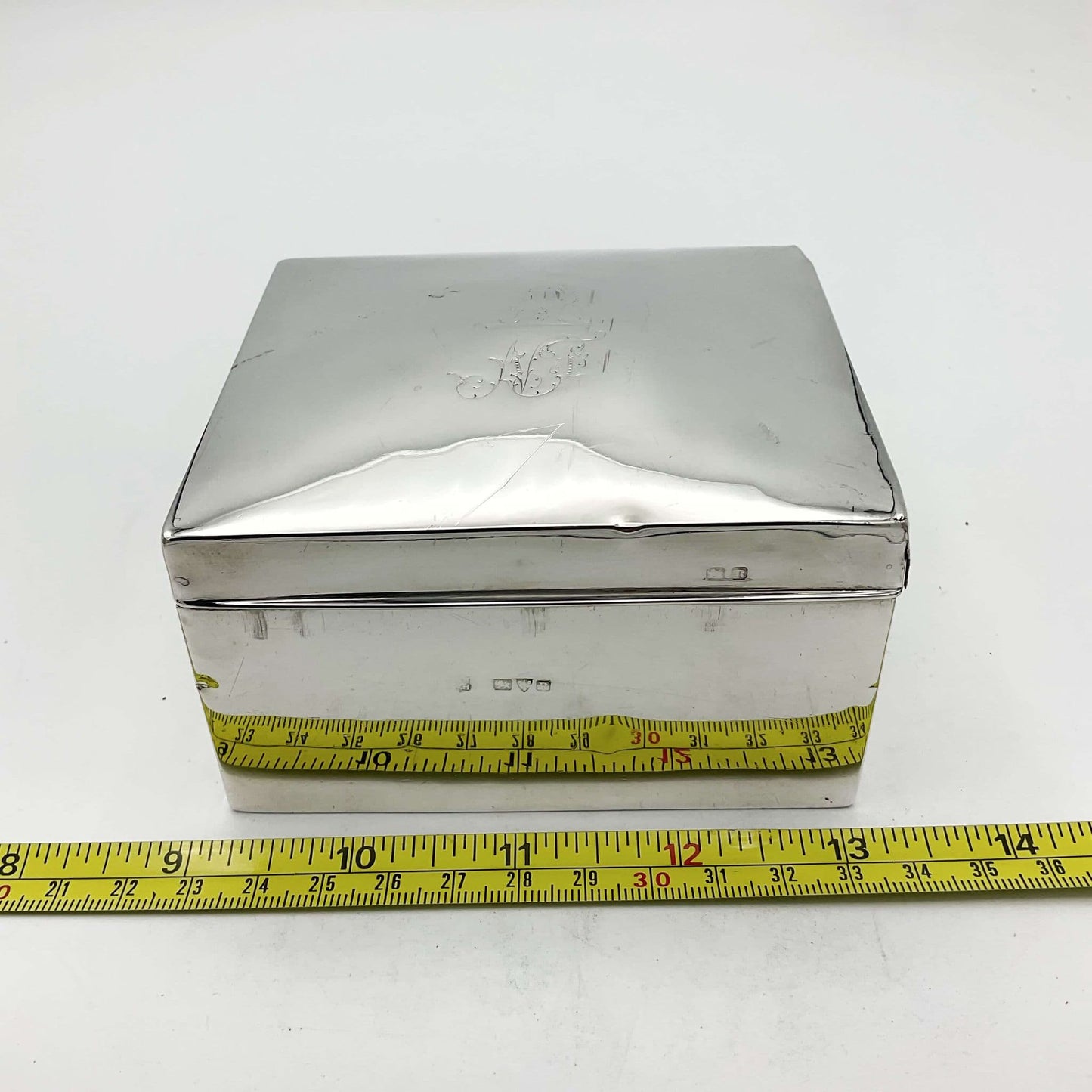 Antique Sterling Silver Cigarette Box next to a tape measure showing the width as approximately 10cm 
