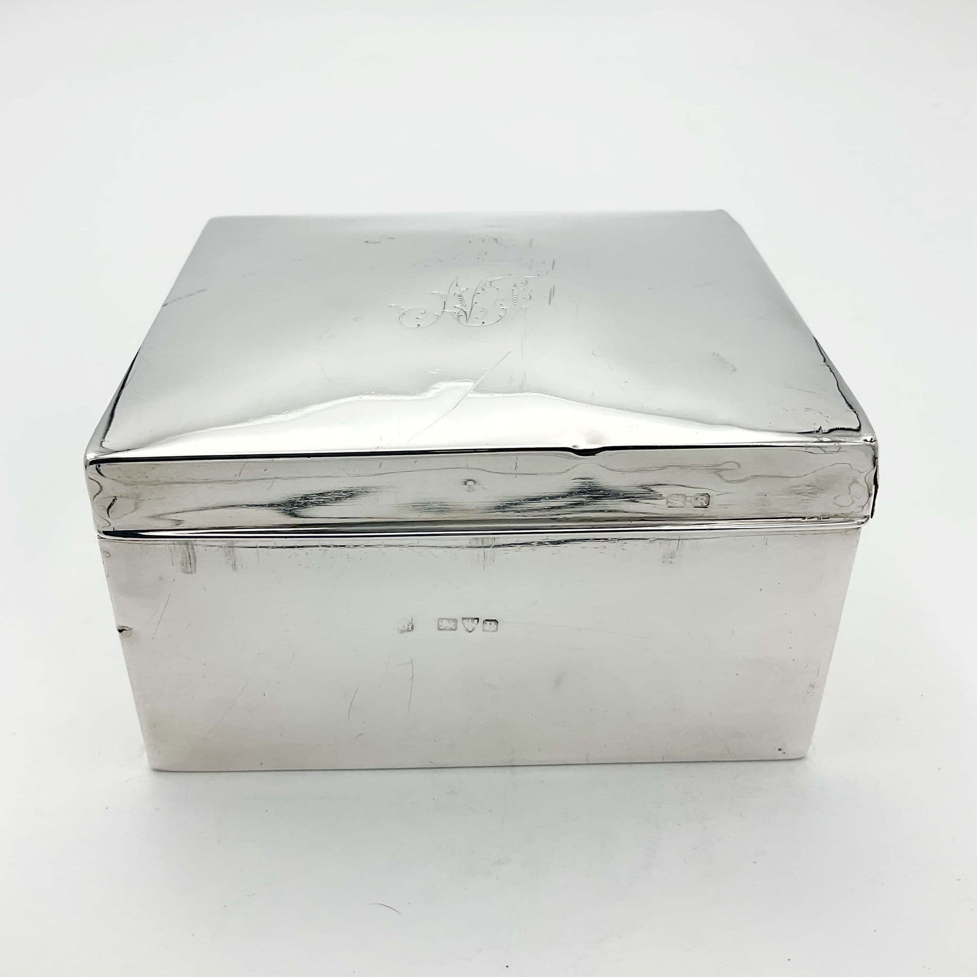 Antique 1900 silver cigarette box with hallmarks at the side on a white background