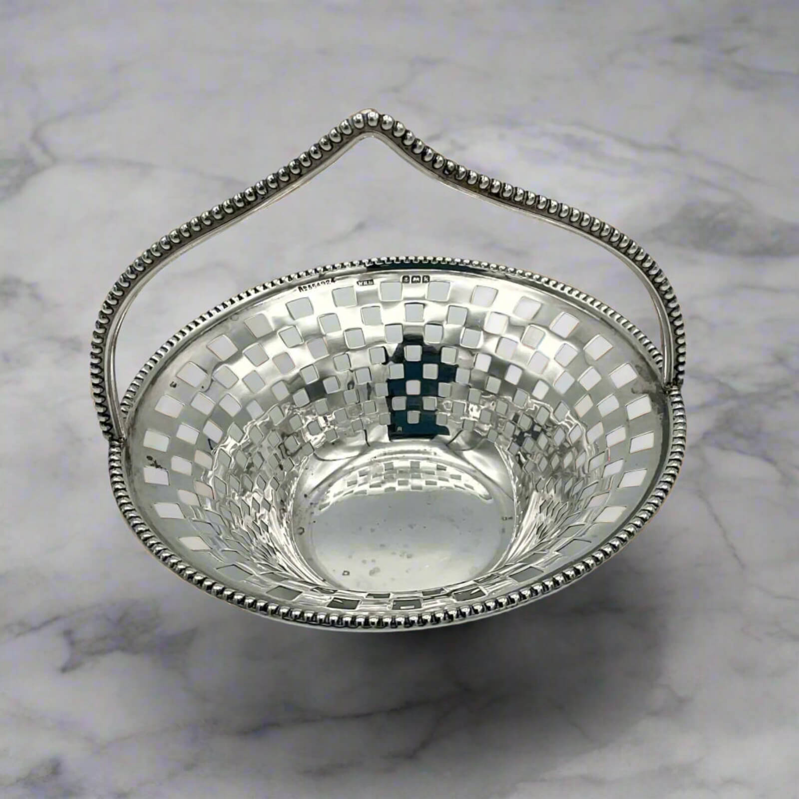 Silver bowl with a checkered pattern on a marble surface