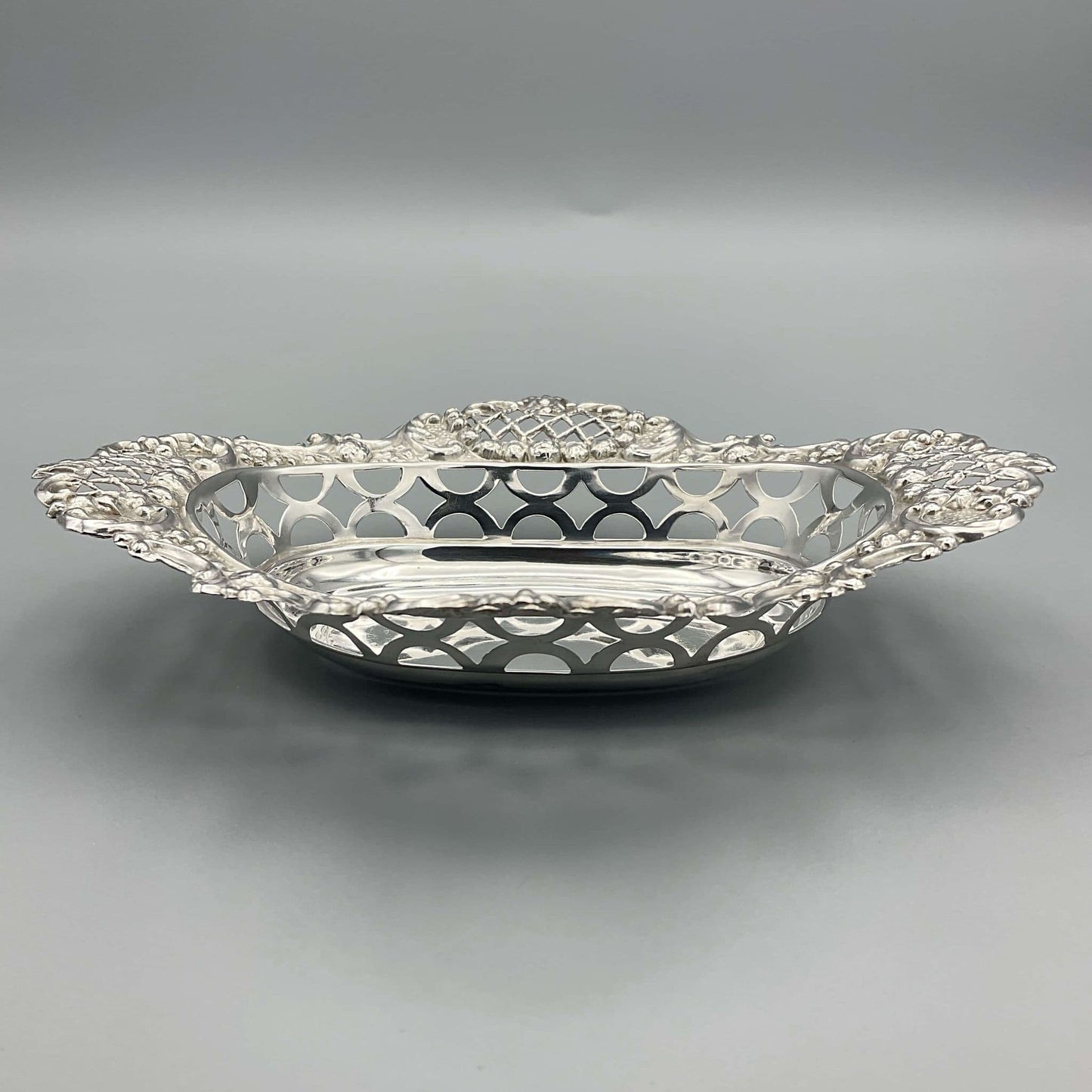 Side view showing pierced design of antique silver bowl