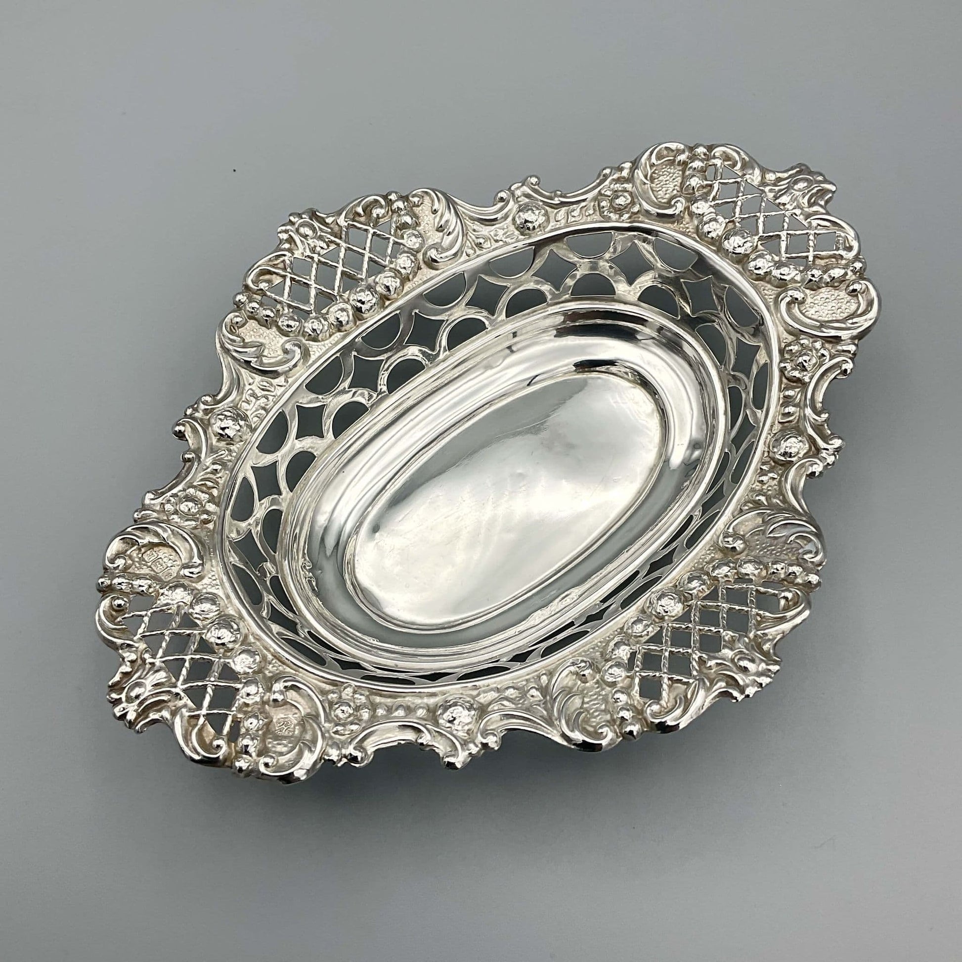 Ornate silver pierced bowl on grey background