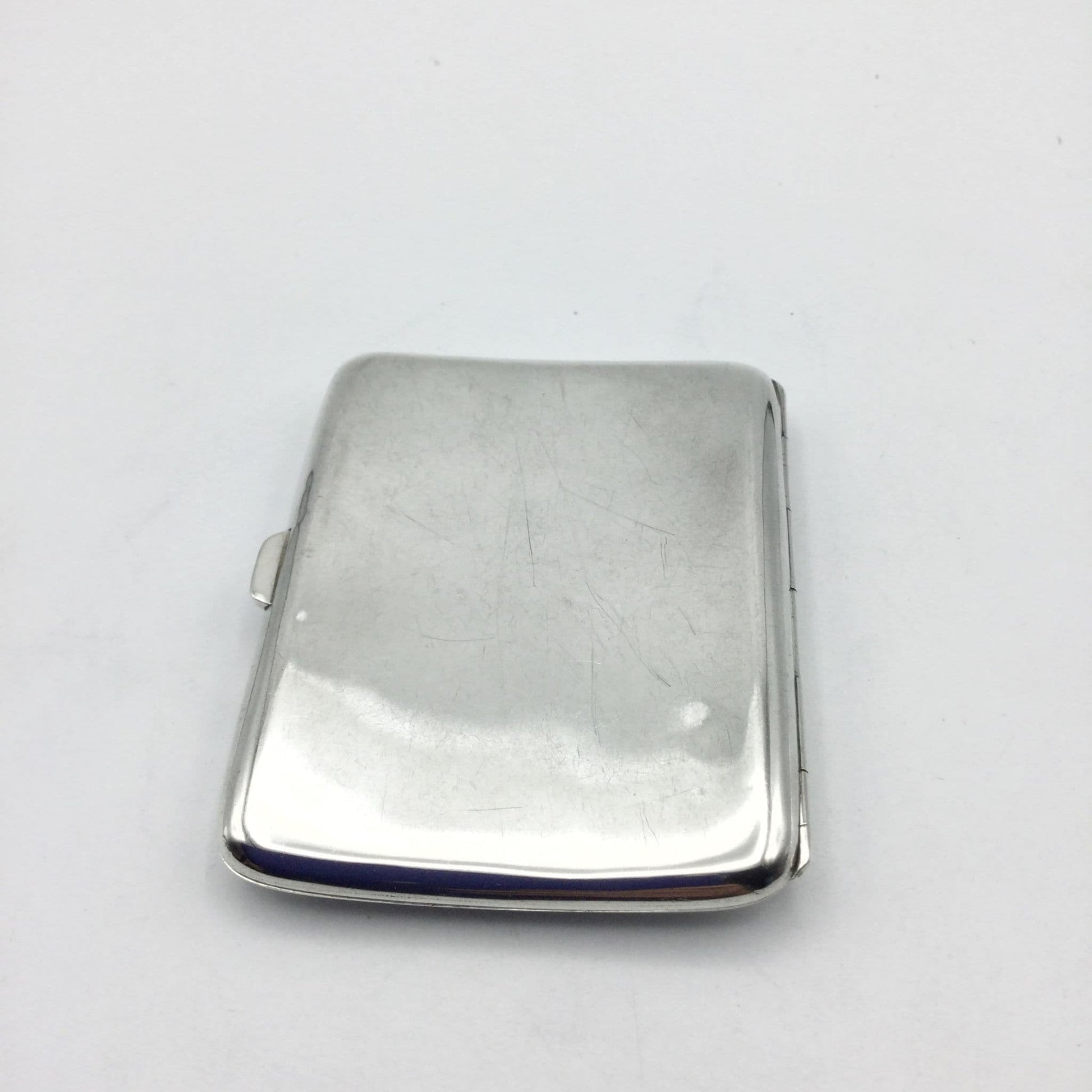 back of shiny 1910s solid silver cigarette case on a white background