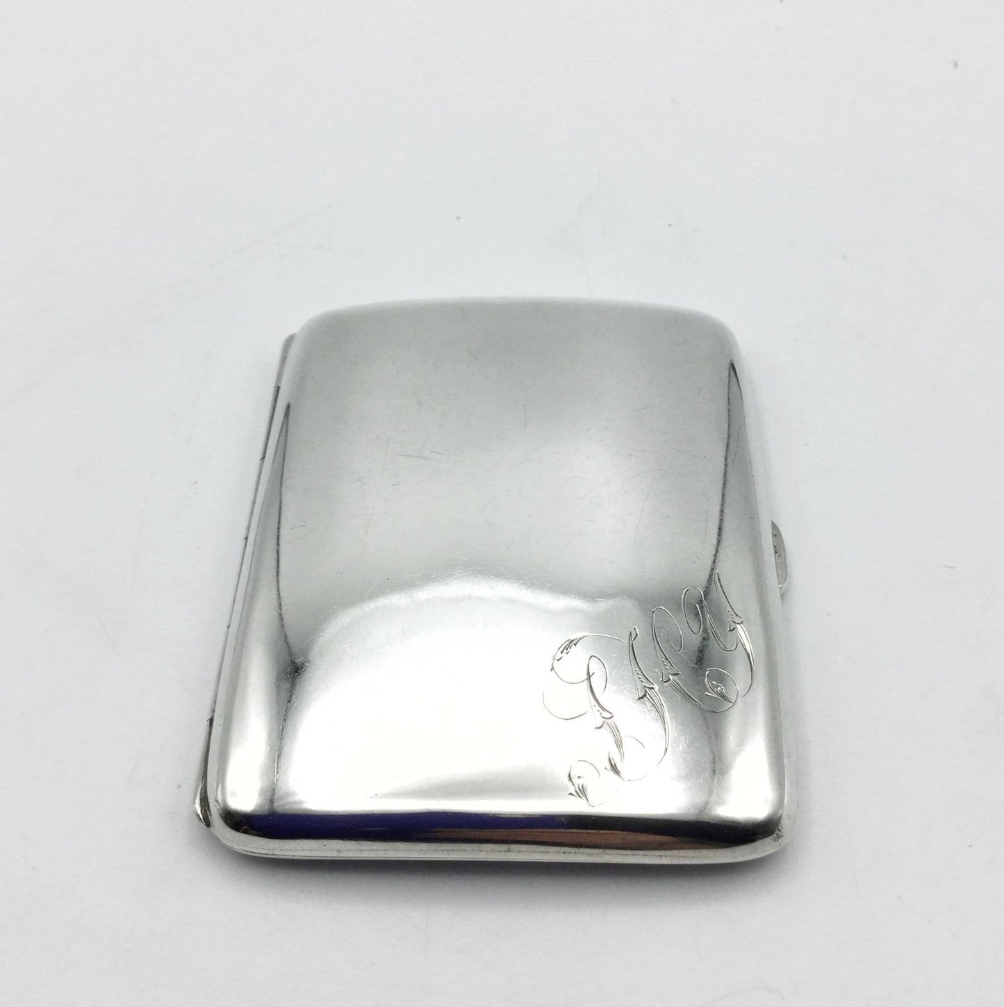 front of antique solid silver cigarette case with JHY engraved in the corner on a white background
