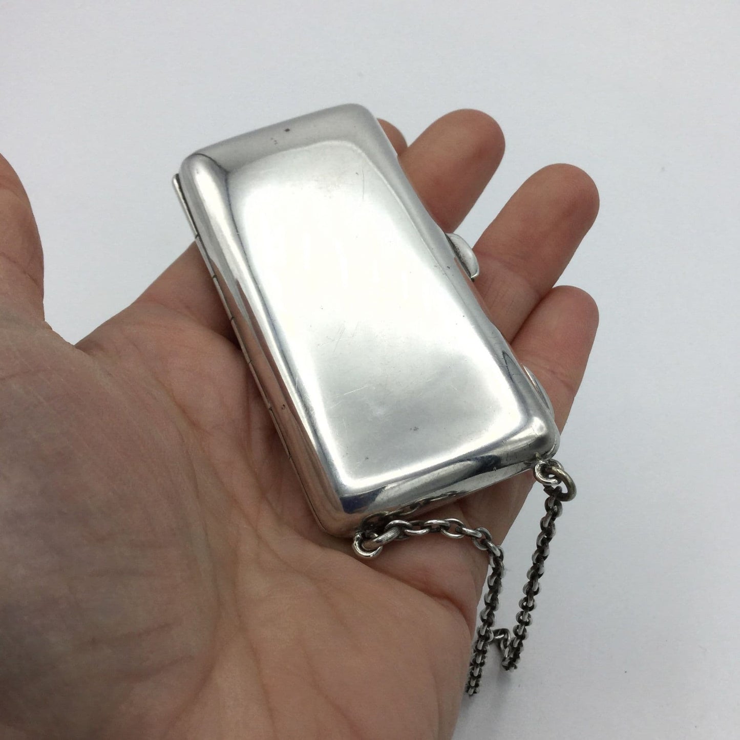 silver case with chain in a hand