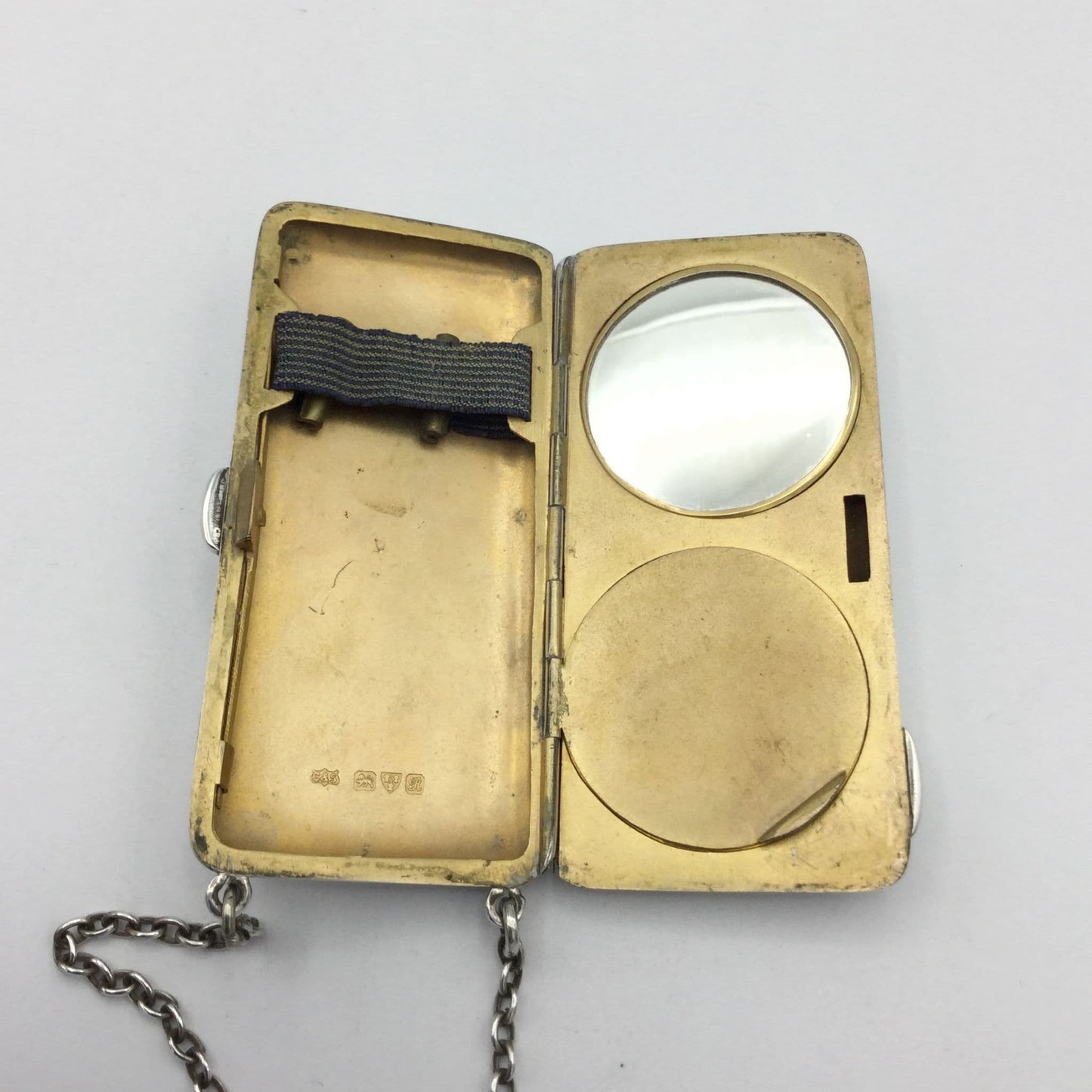 gilded golden inside of case showing a mirror, powder area and chain