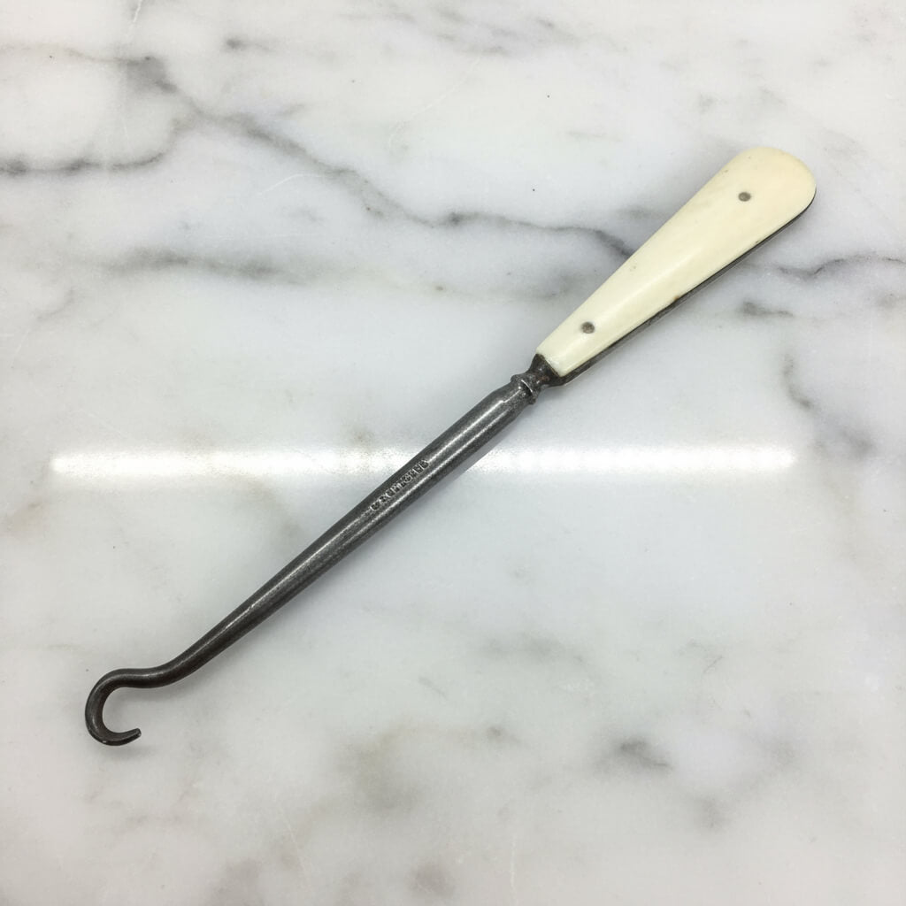 Antique bone handled button hook on a white background and the Rodgers name and logo on the steel hook