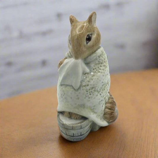 chippy hackee figurine holding a white cloth on a wooden surface with a blurred background