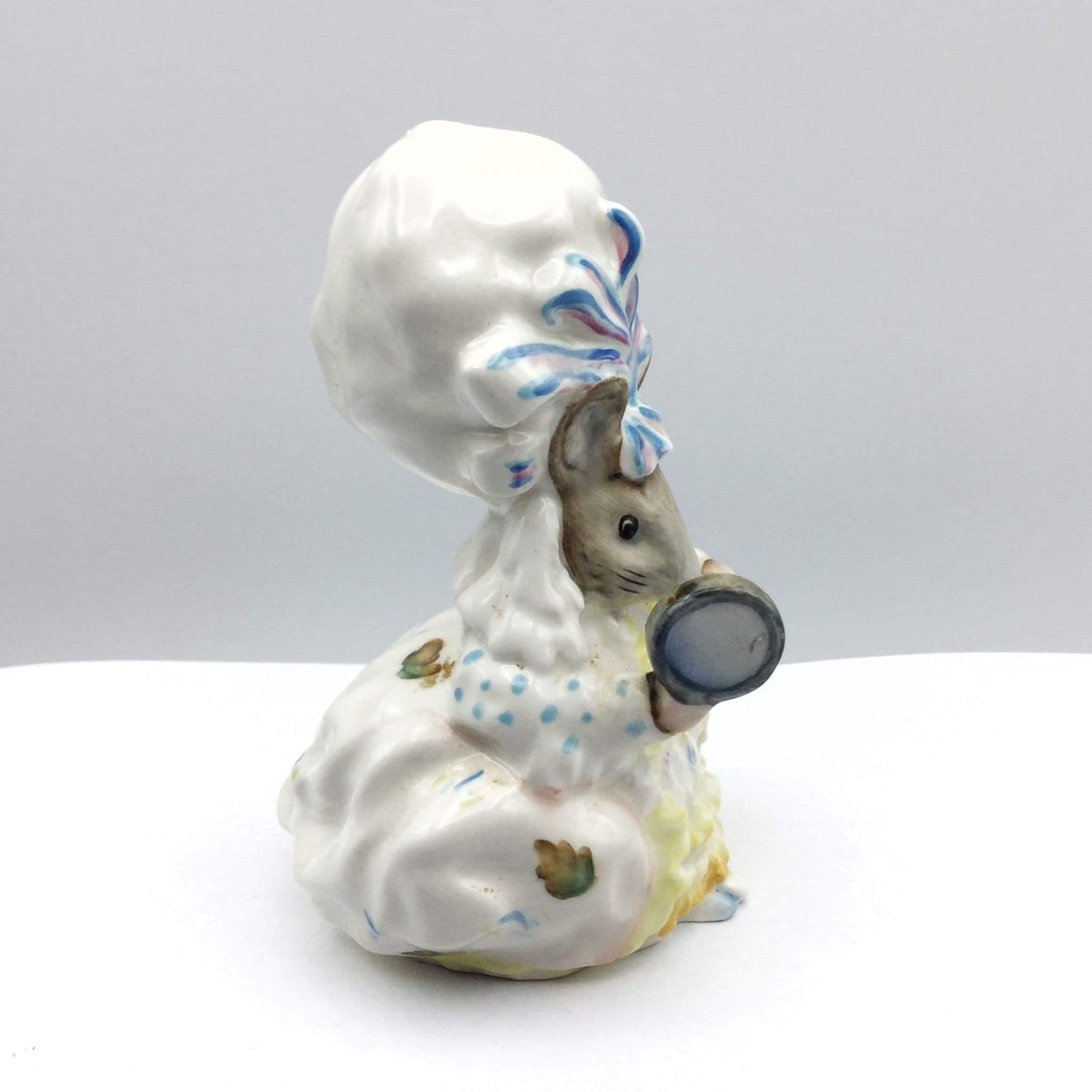 Decorative figurine of a mouse with a chef's hat and oversized spoon on a white background