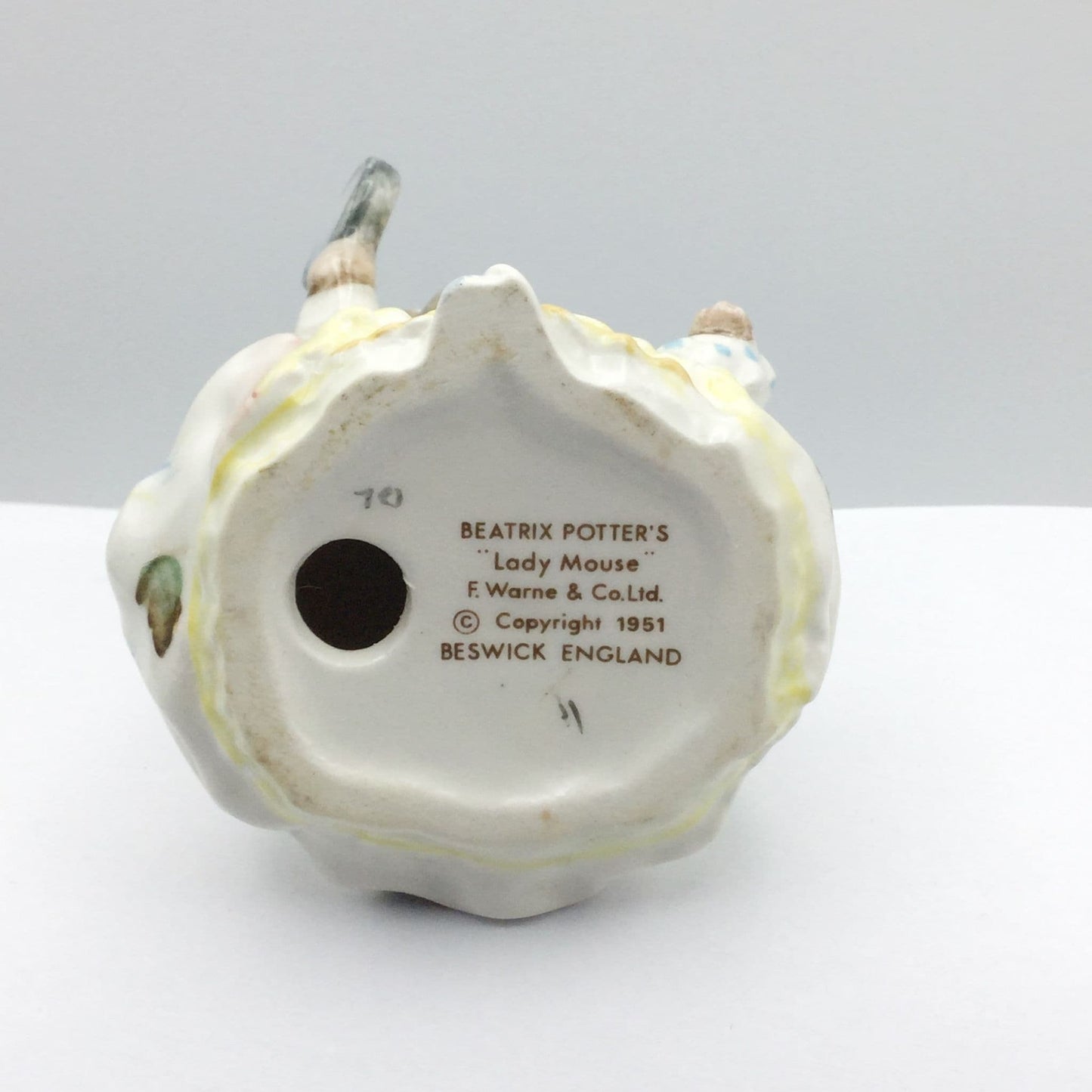 Back view of a ceramic figure with 'Beatrix Potter's Lady Mouse' text on a white background
