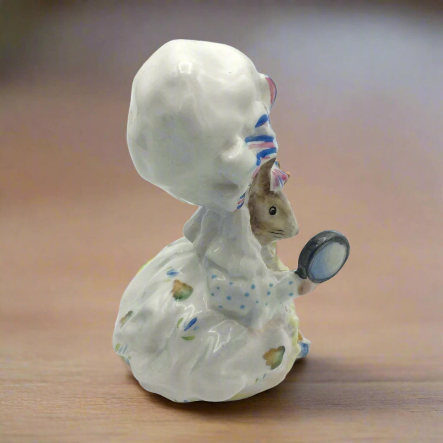 Ceramic figurine of lady mouse on a wooden surface