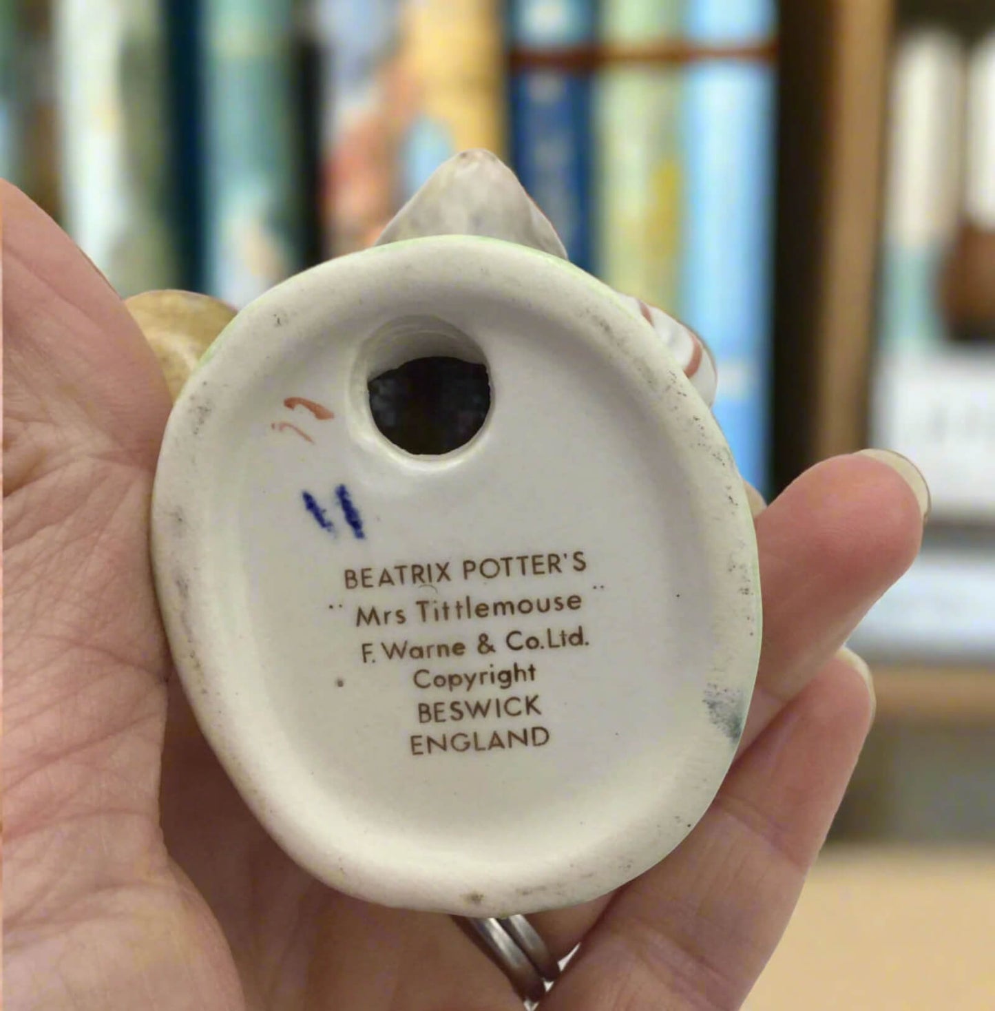 Ceramic figurine with 'Beatrix Potter's Mrs Tittlemouse' text on a blurred background