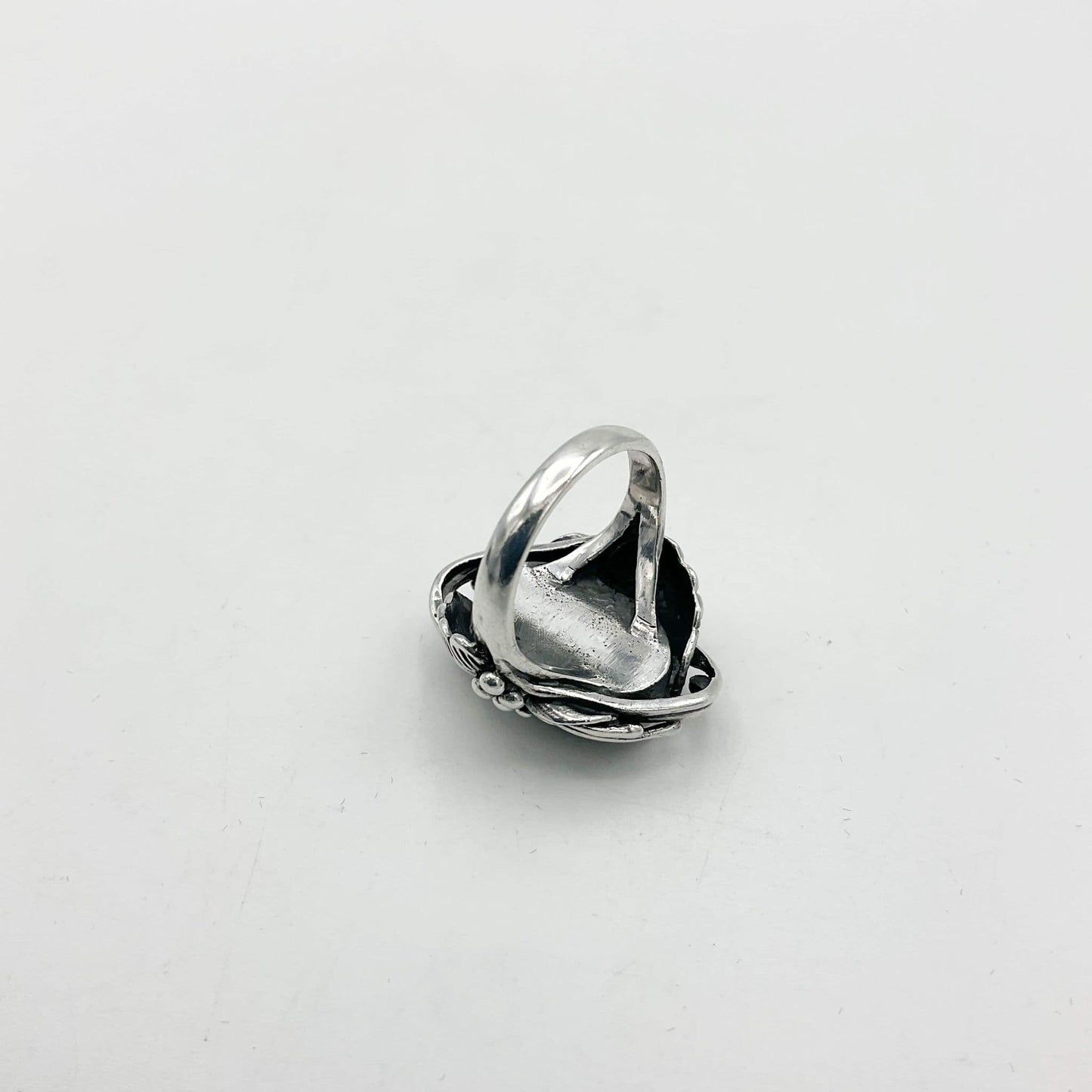 Silver ring upside down on white background showing silver band