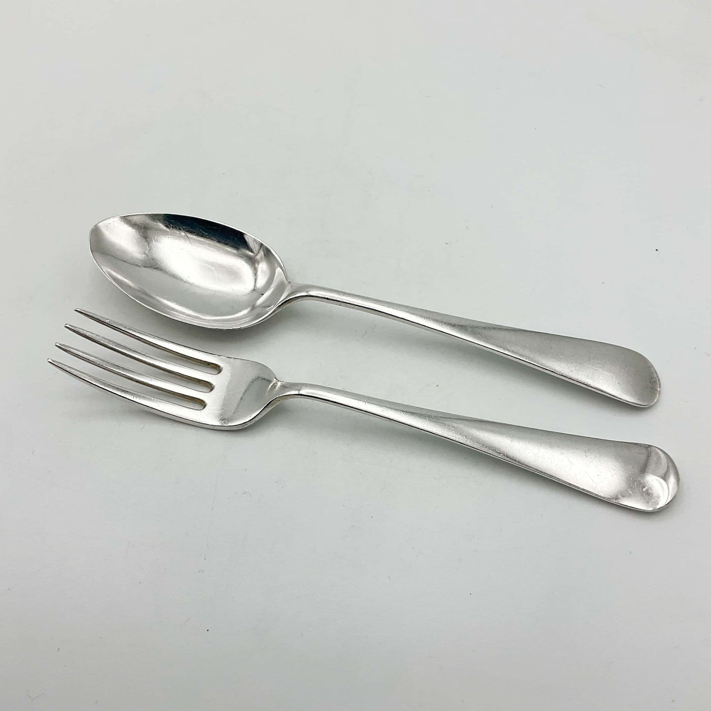 Child’s Solid silver fork and spoon set on white background 