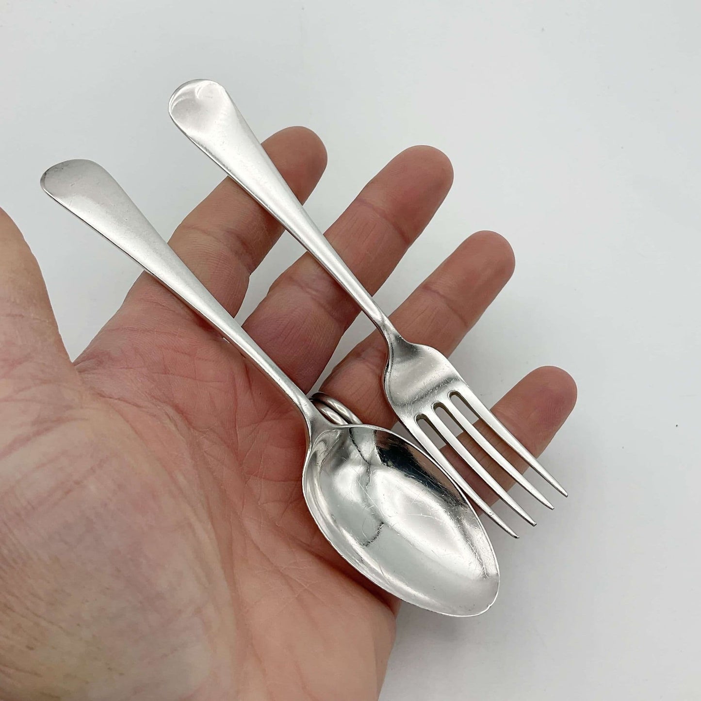 Small child’s spoon and fork set in a hand