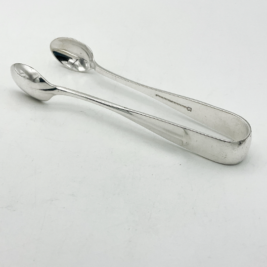 rat tail design on silver plated sugar tongs on a white background