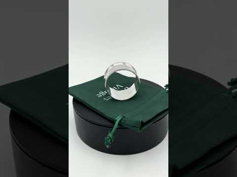 Video short of Shiny silver napkin ring on a green cotton gift bag on a turntable