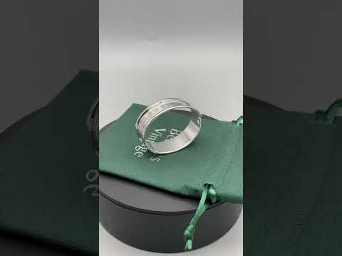 video short of Engraved silver napkin ring sitting on a green cotton bag on a turntable