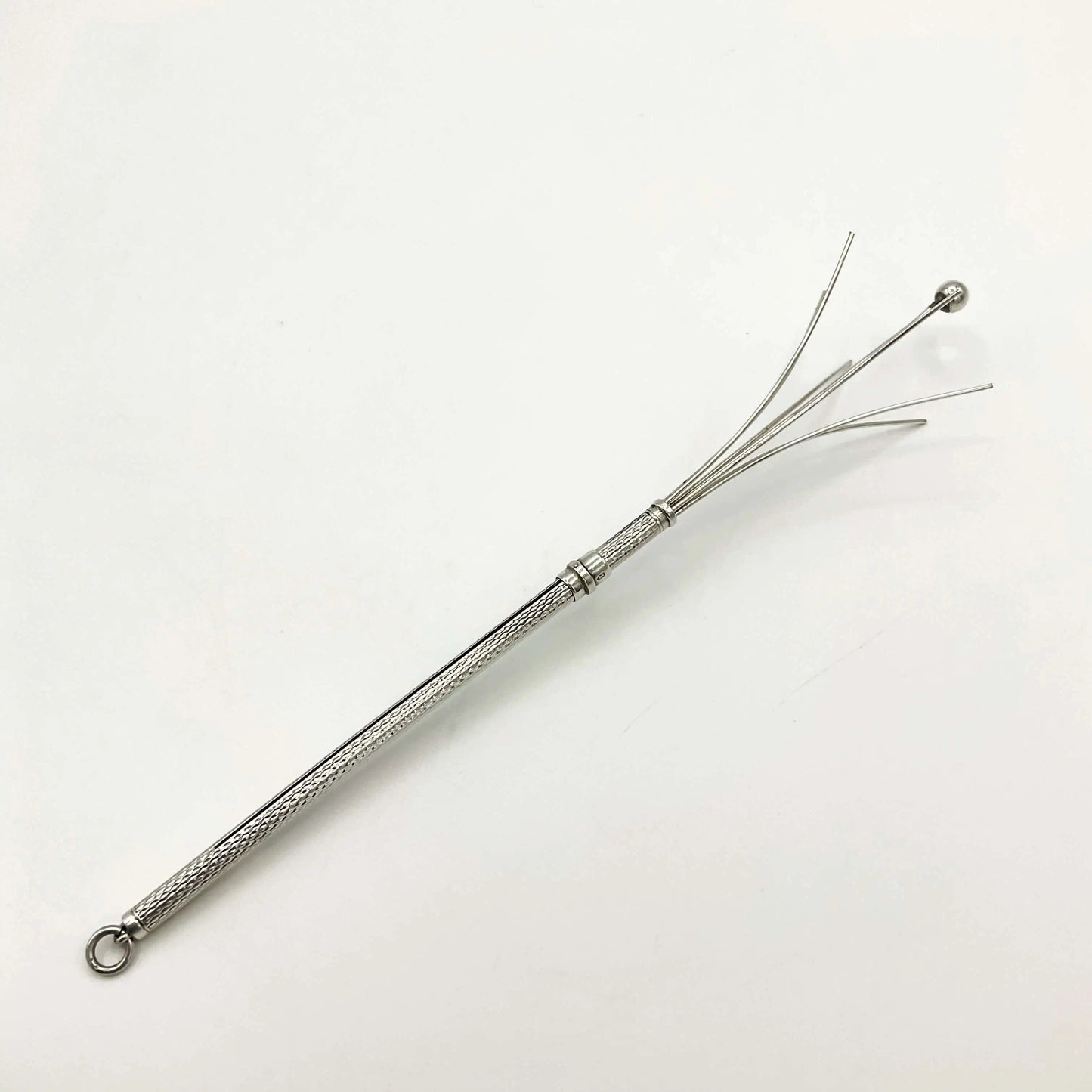 Silver whisk with decorative handle on a white background