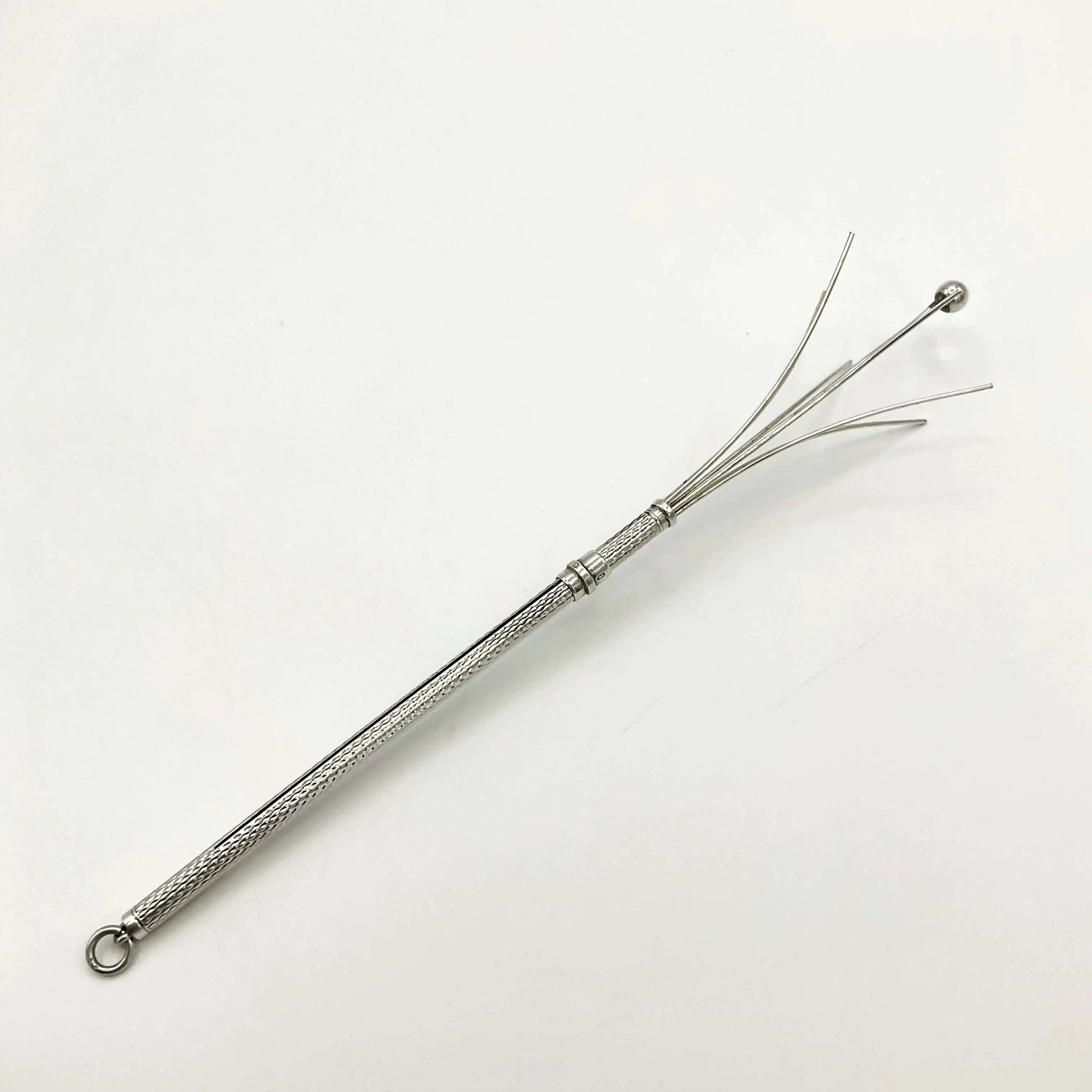 Silver whisk with decorative handle on a white background