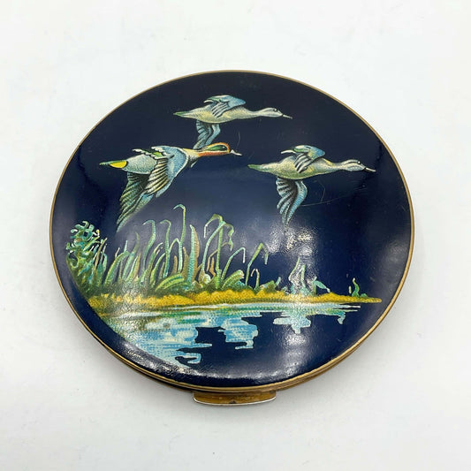 beautiful enamel featuring three ducks flying over water on a mirror compact lid