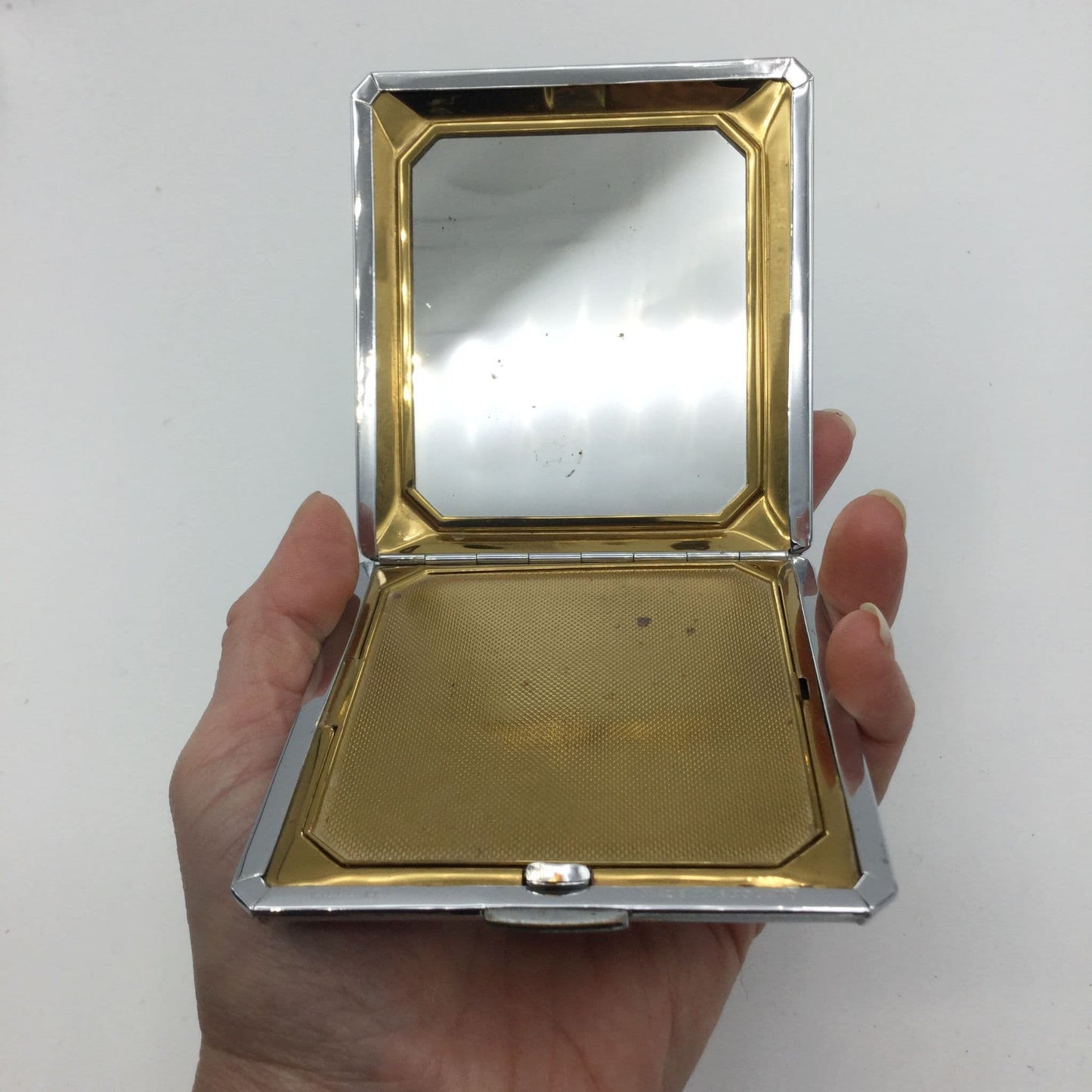 gold interior to compact showing the mirror