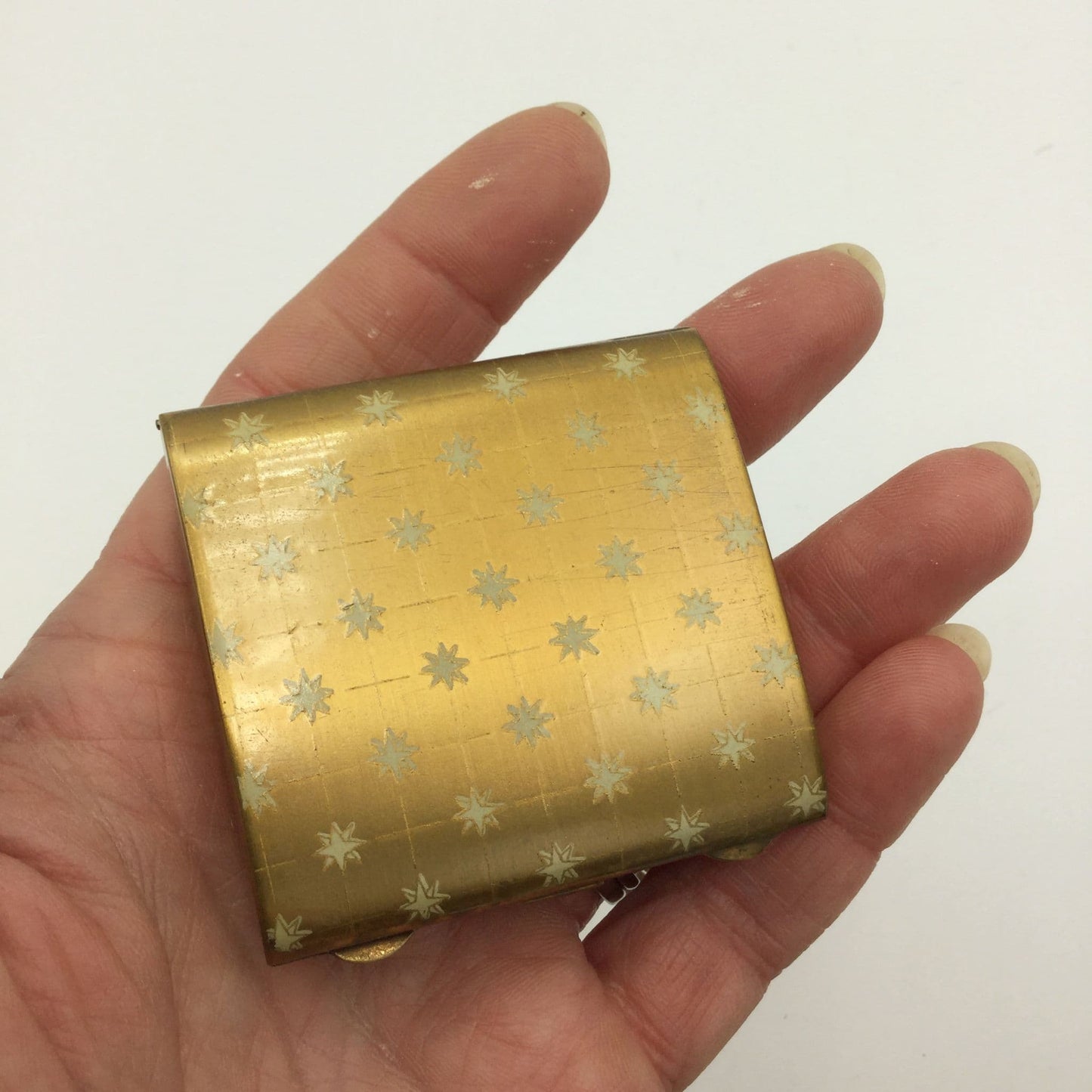 rectangular gold mirror compact in a hand