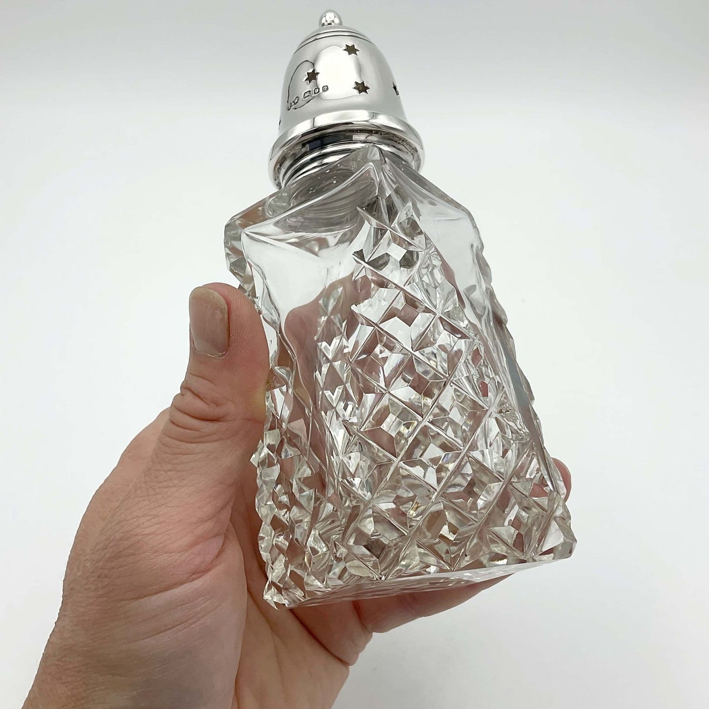Crystal glass design to sides of sugar shaker held in a hand