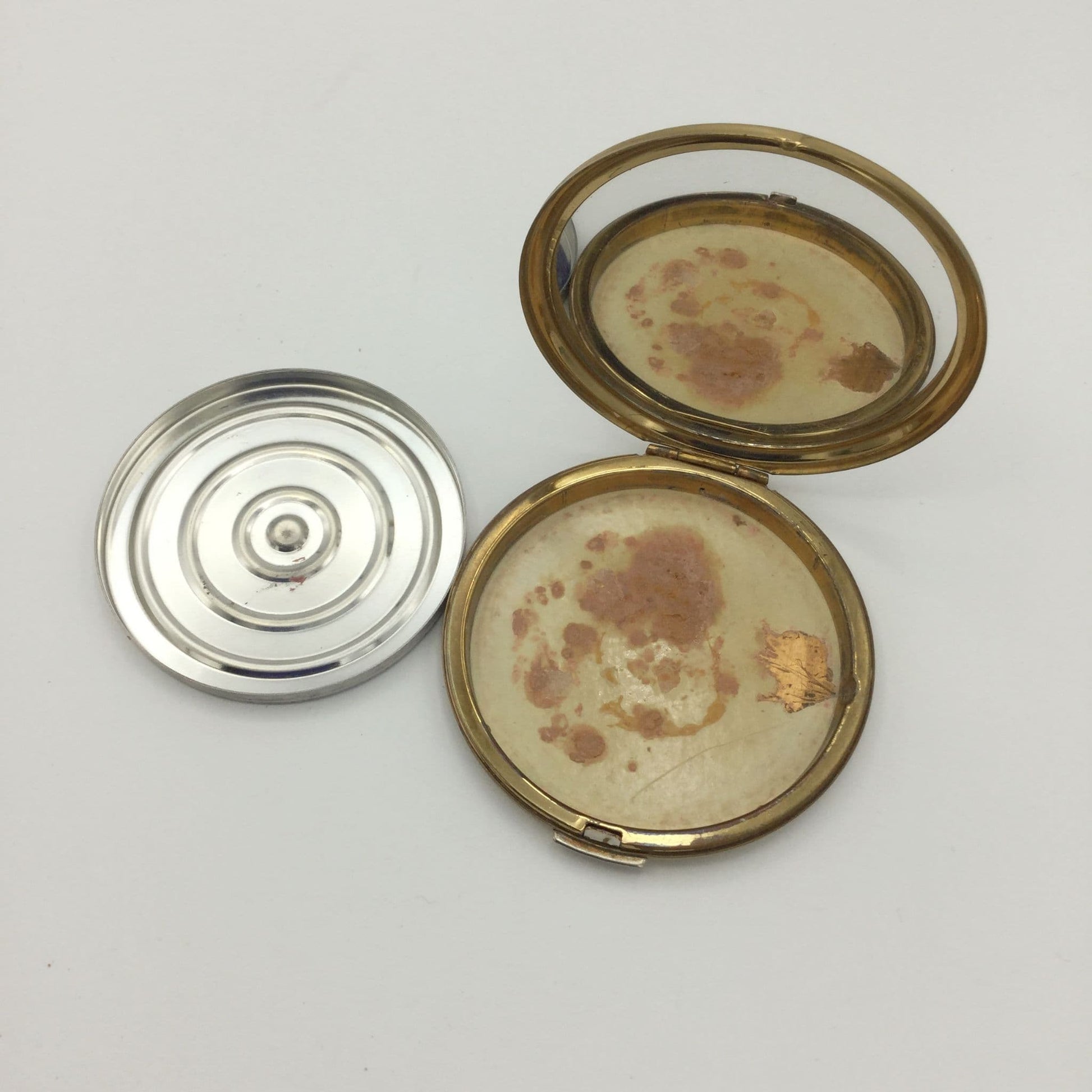 inside of Stratton mirror compact showing a relective mirror and a powder base to one side