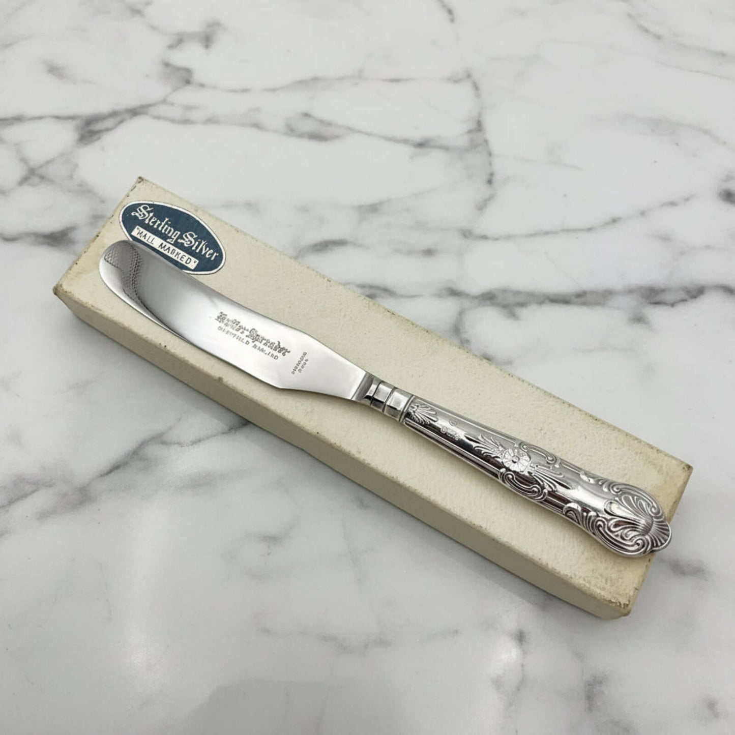 Vintage 1978 Sterling Silver Handled Butter Knife on a box and marble background