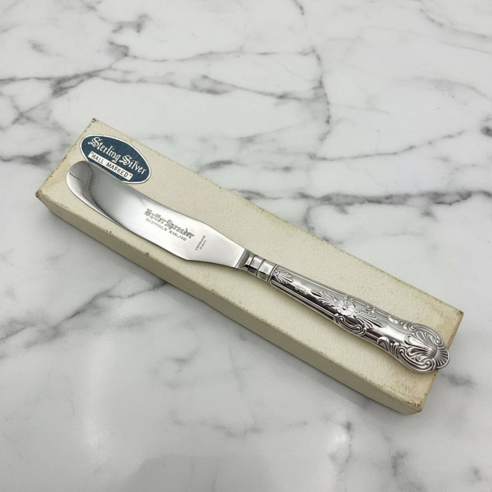 Vintage 1978 Sterling Silver Handled Butter Knife on a box and marble background