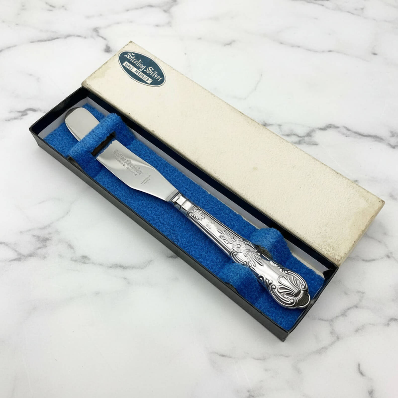 Vintage 1978 Sterling Silver Handled Butter Knife in a box on a marble background