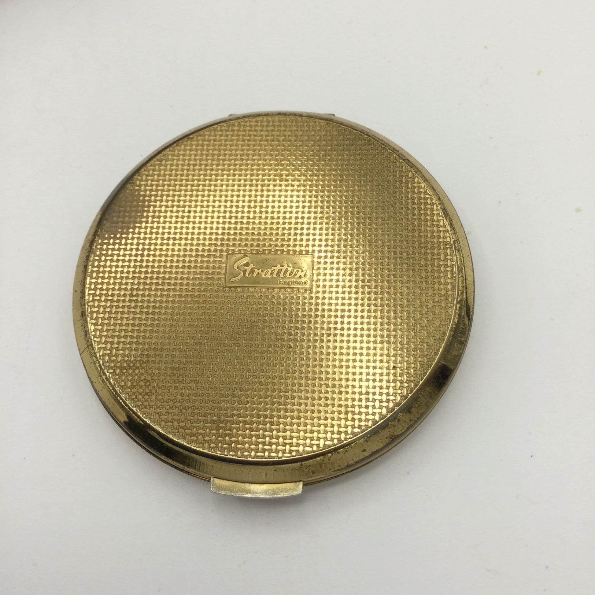Base of Stratton compact with woven gold design on base