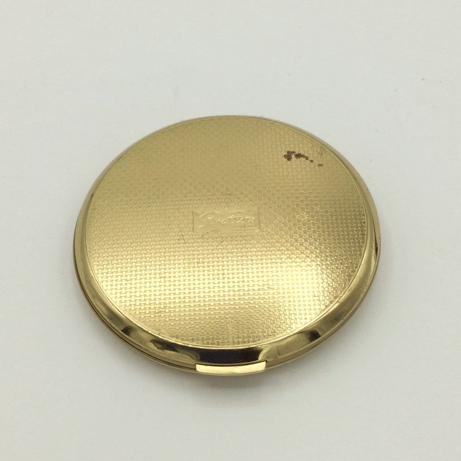 Golden woven base of a Stratton powder compact